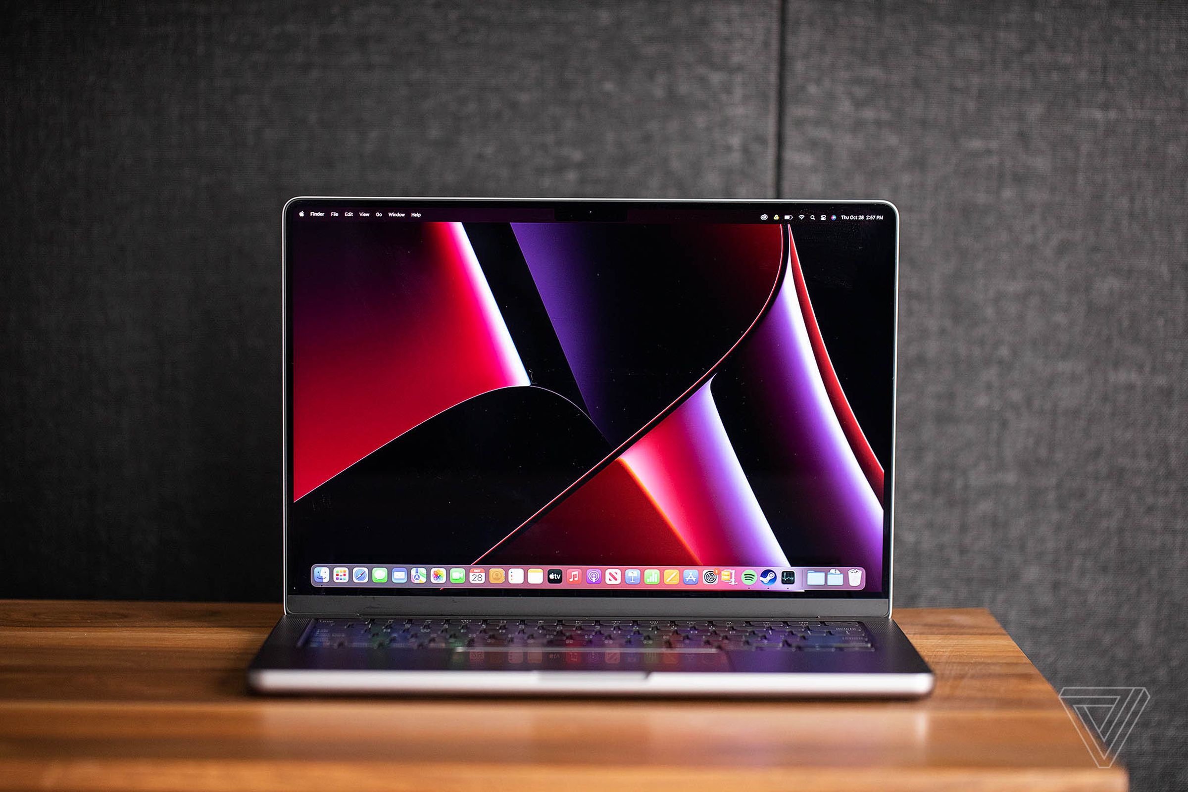 Apple’s 2021 14-inch MacBook Pro sitting turned on and open with its screen facing the camera on a desk.