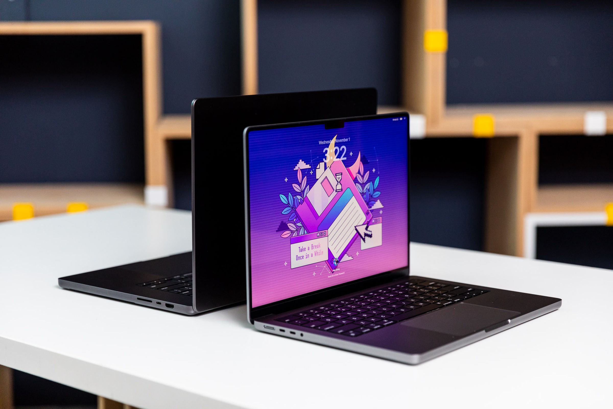 14-inch MacBook Pro angled on a desk with the 16-inch behind it.