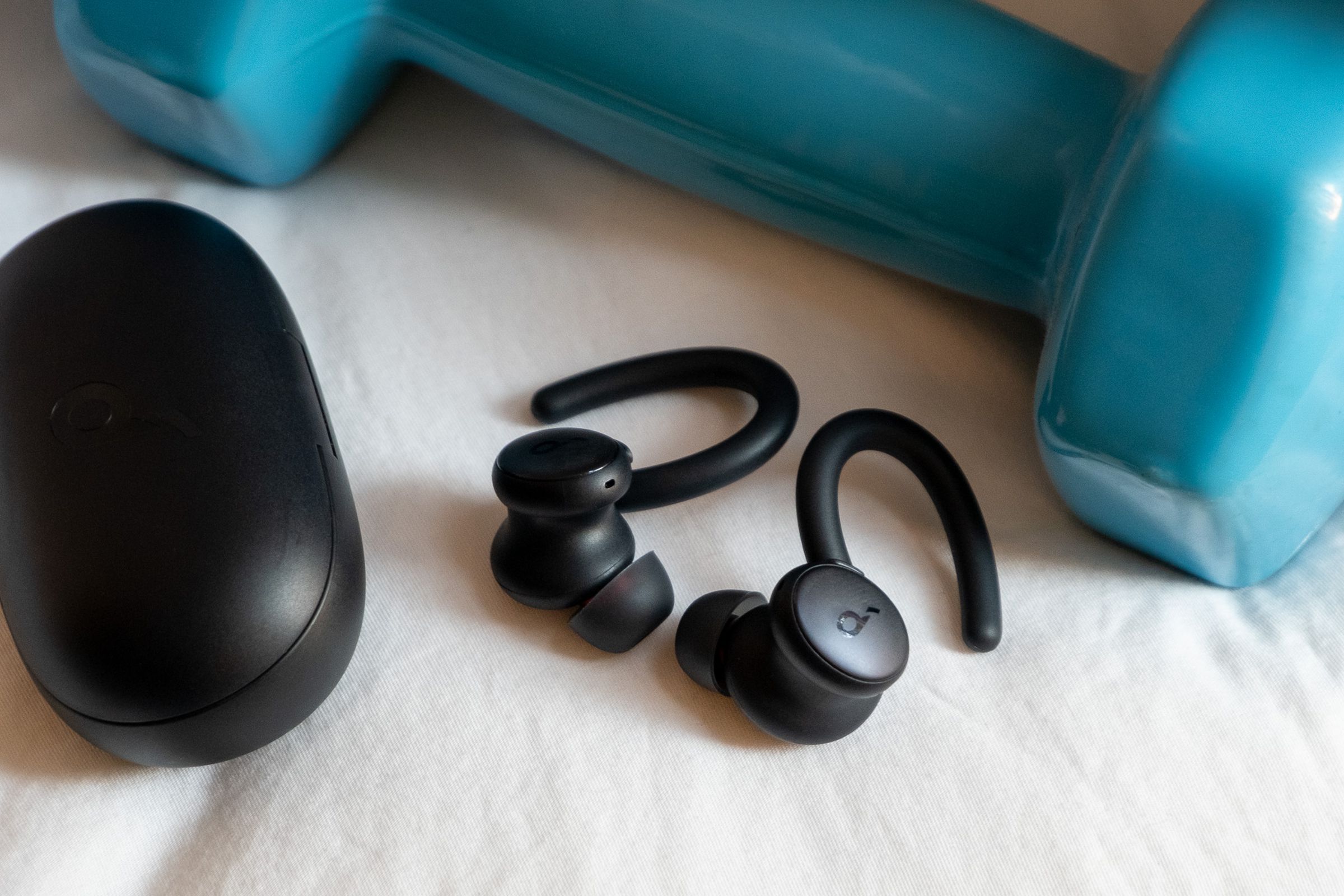 An image of Soundcoreâs Sport X10 earbuds next to a weight.