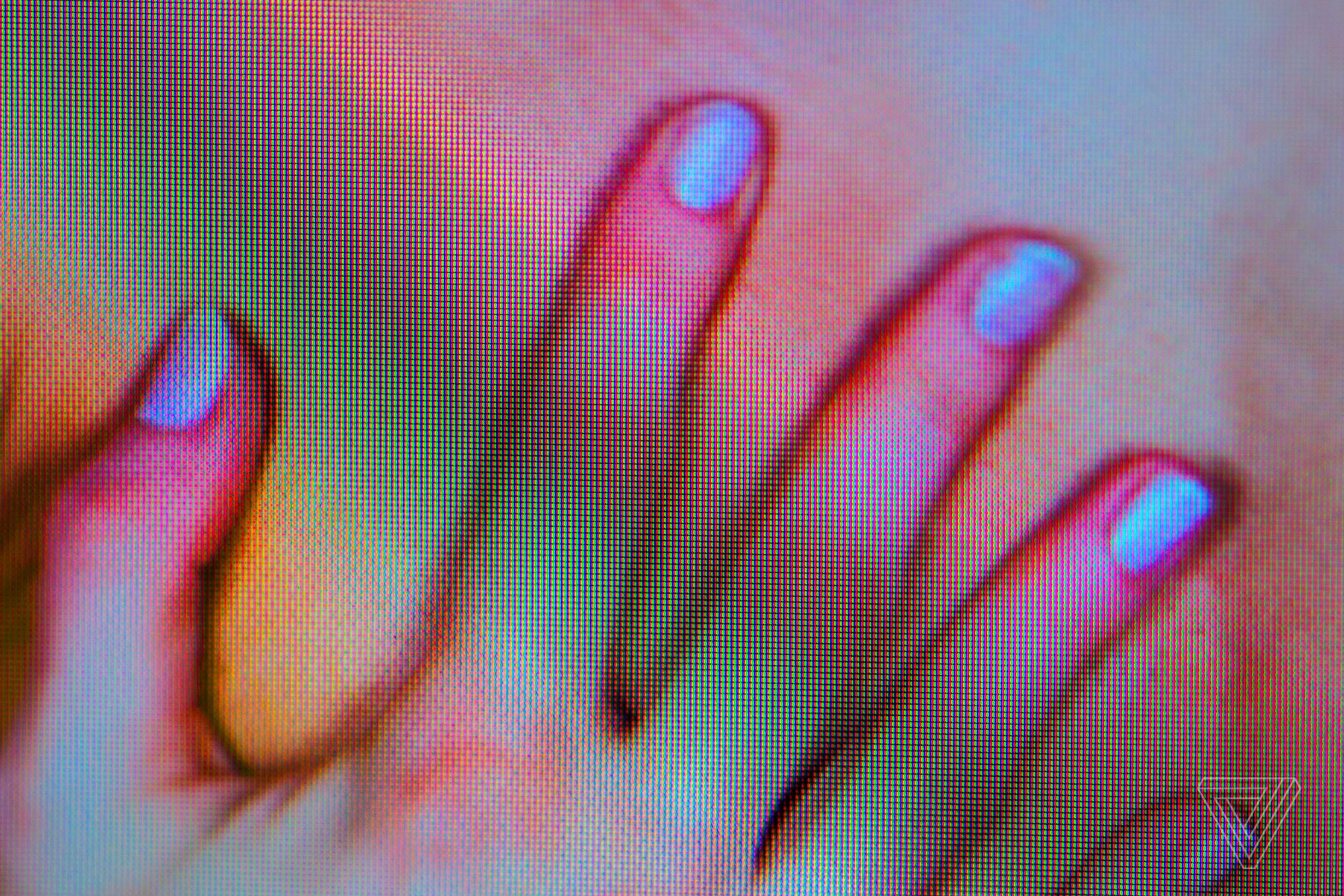 Blurry screenshot of a female hand touching her skin on a device.