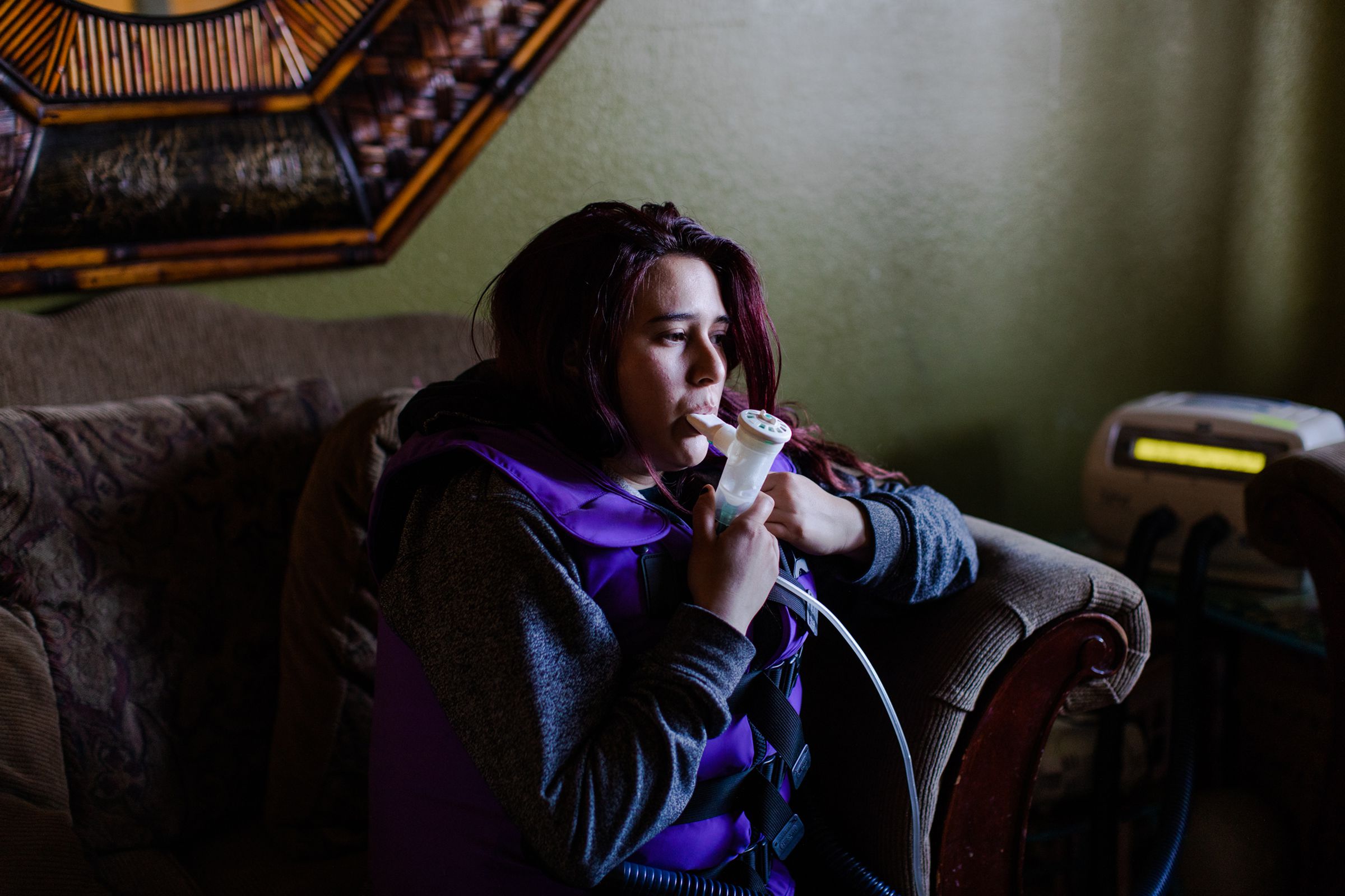 Michelle Dugan takes her nebulizer treatment in her home wearing a vest that delivers High Frequency Chest Wall Oscillation therapy.