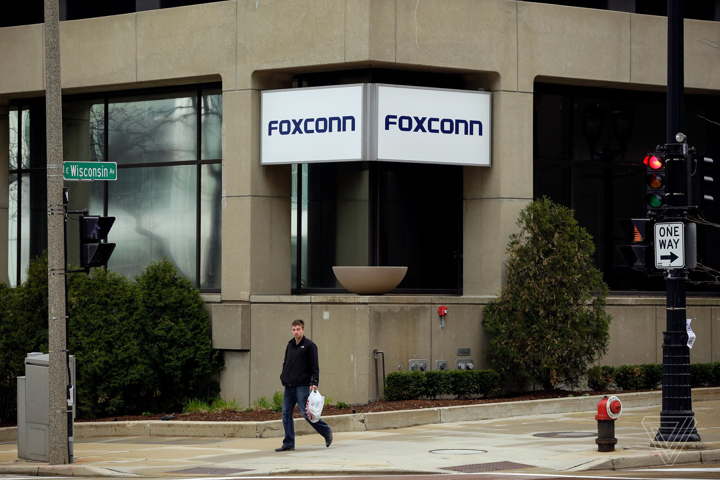 A man walks past an office building with the Foxconn name displayed outside on Wednesday, May 8 2019 in Milwaukee, Wisconsin.