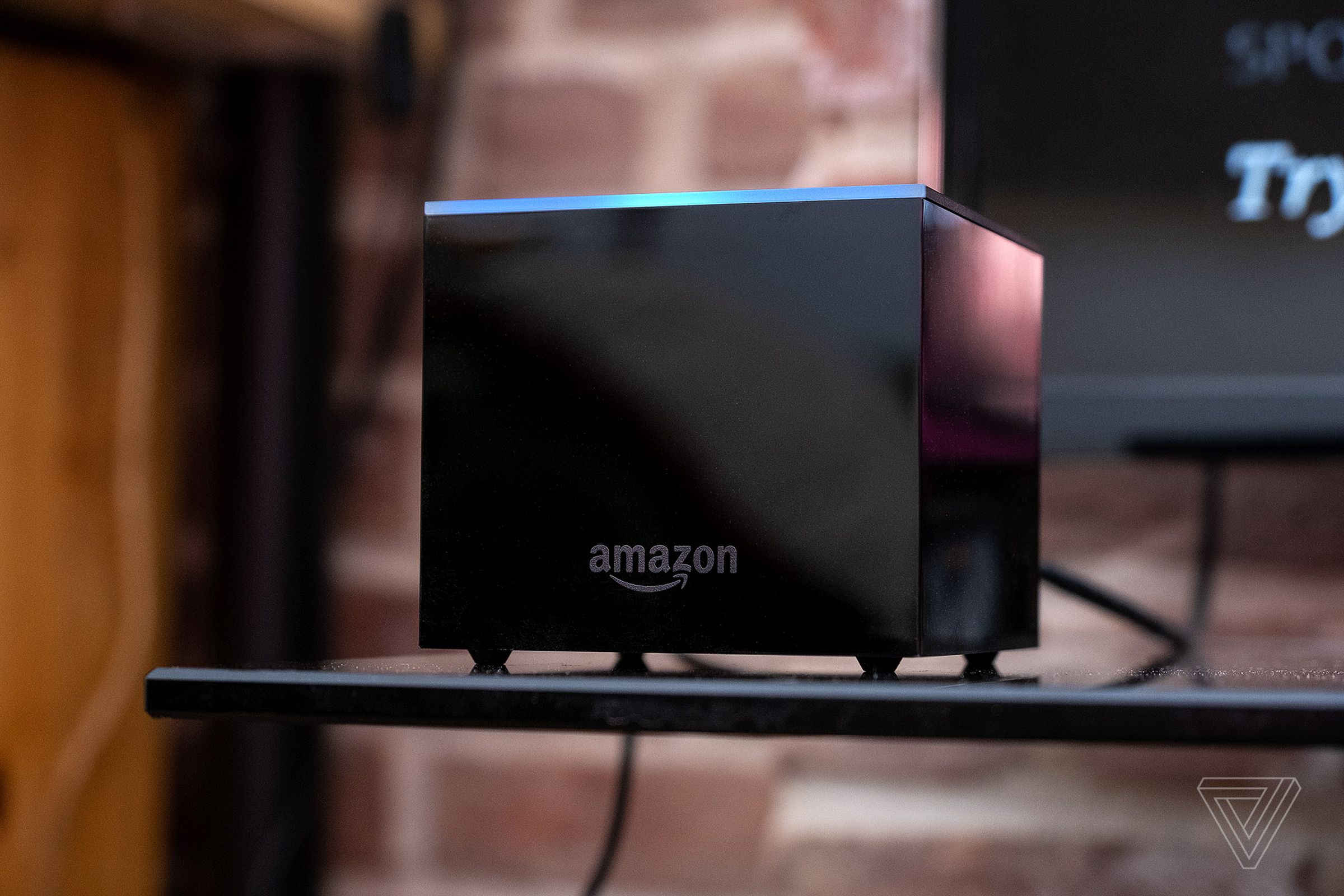Amazon’s Fire TV Cube, the best streaming player if you don’t have a smart speaker, pictured on a TV stand.
