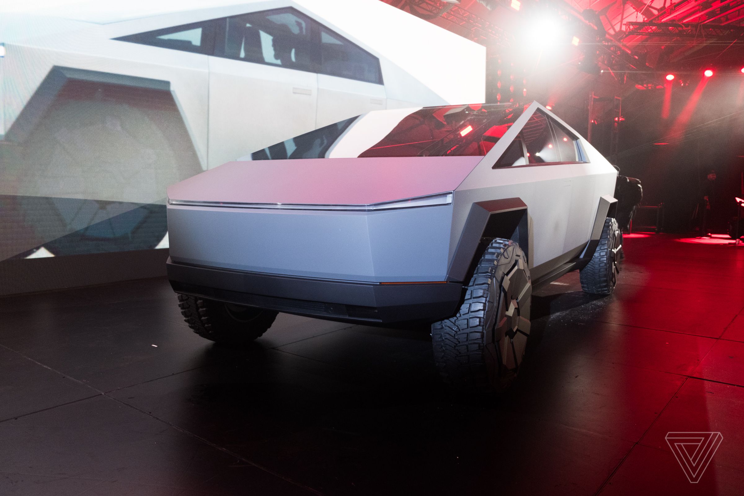Tesla Cybertruck prototype in 2019, sitting on a stage in front of a massive projection screen.