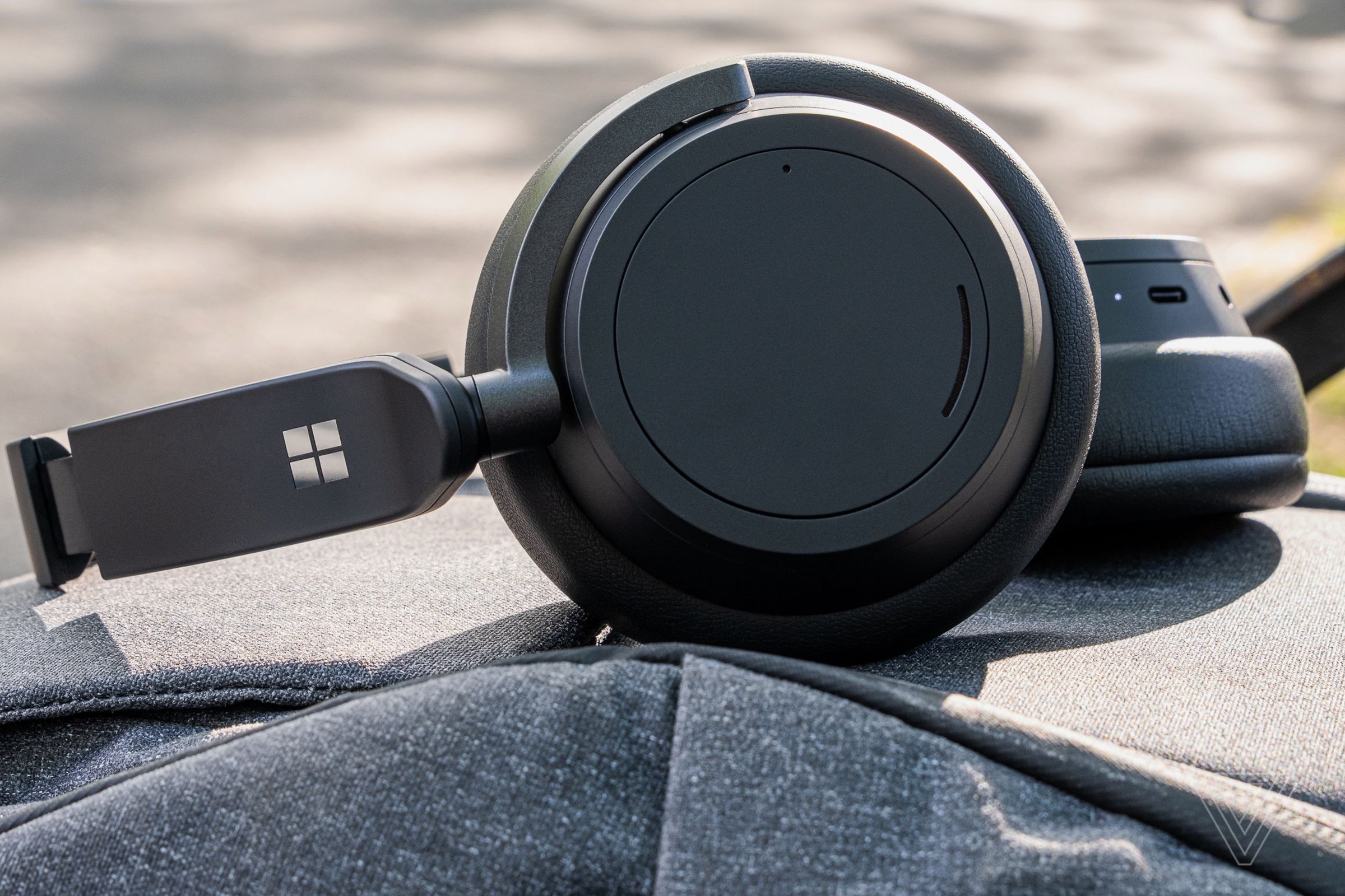 An image of the Surface Headphones 2, the best noise-canceling headphones for ease of use, resting on a backpack.
