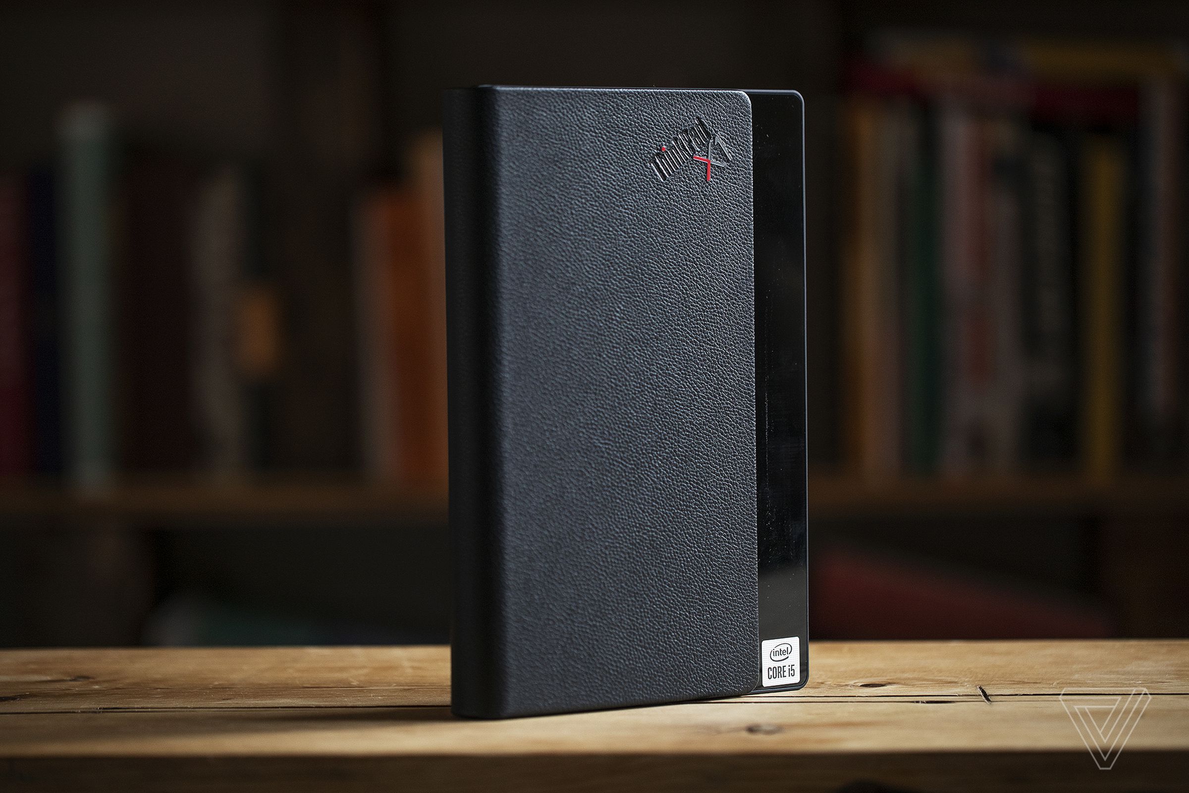 The Lenovo ThinkPad X1 Fold closed, standing upright on a table.