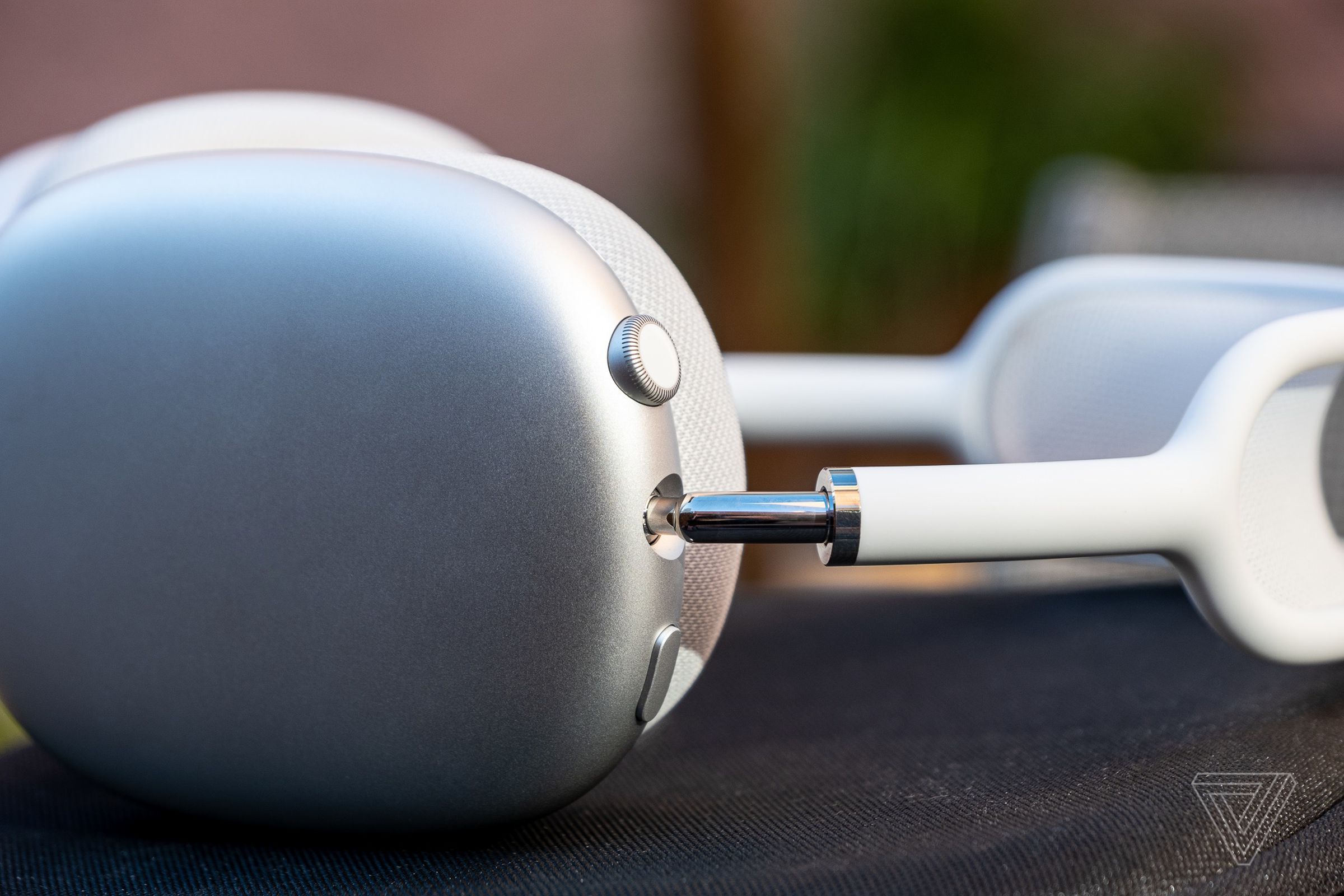 A close up of the Digital Crown on a silver pair of Apple AirPods Max earbuds.