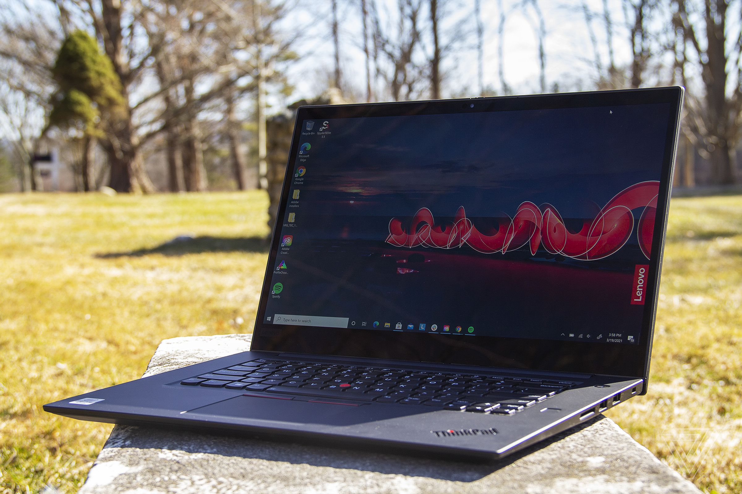 The Thinkpad X1 Extreme Gen 3 angled to the left, open. The screen displays a nighttime outdoor scene with the Lenovo logo on the right side. 