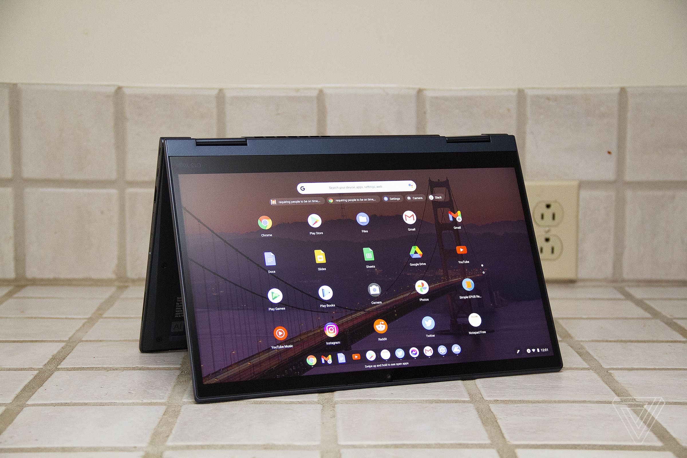 The ThinkPad C13 Yoga Chromebook in tent mode. The screen displays a grid of Android apps.