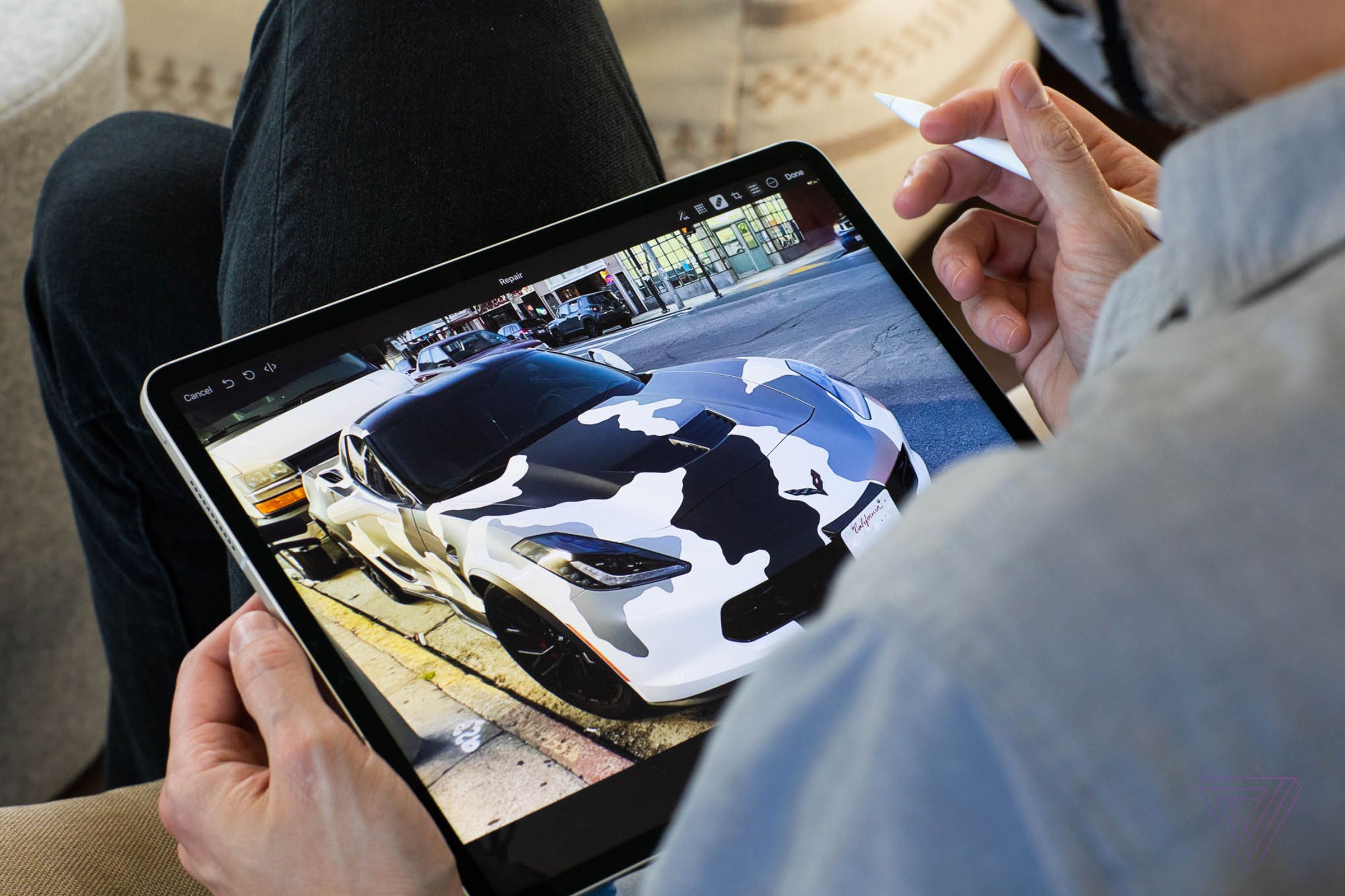 iPad Pro no colo de uma pessoa enquanto ela usa um Apple Pencil para editar uma foto no tablet.