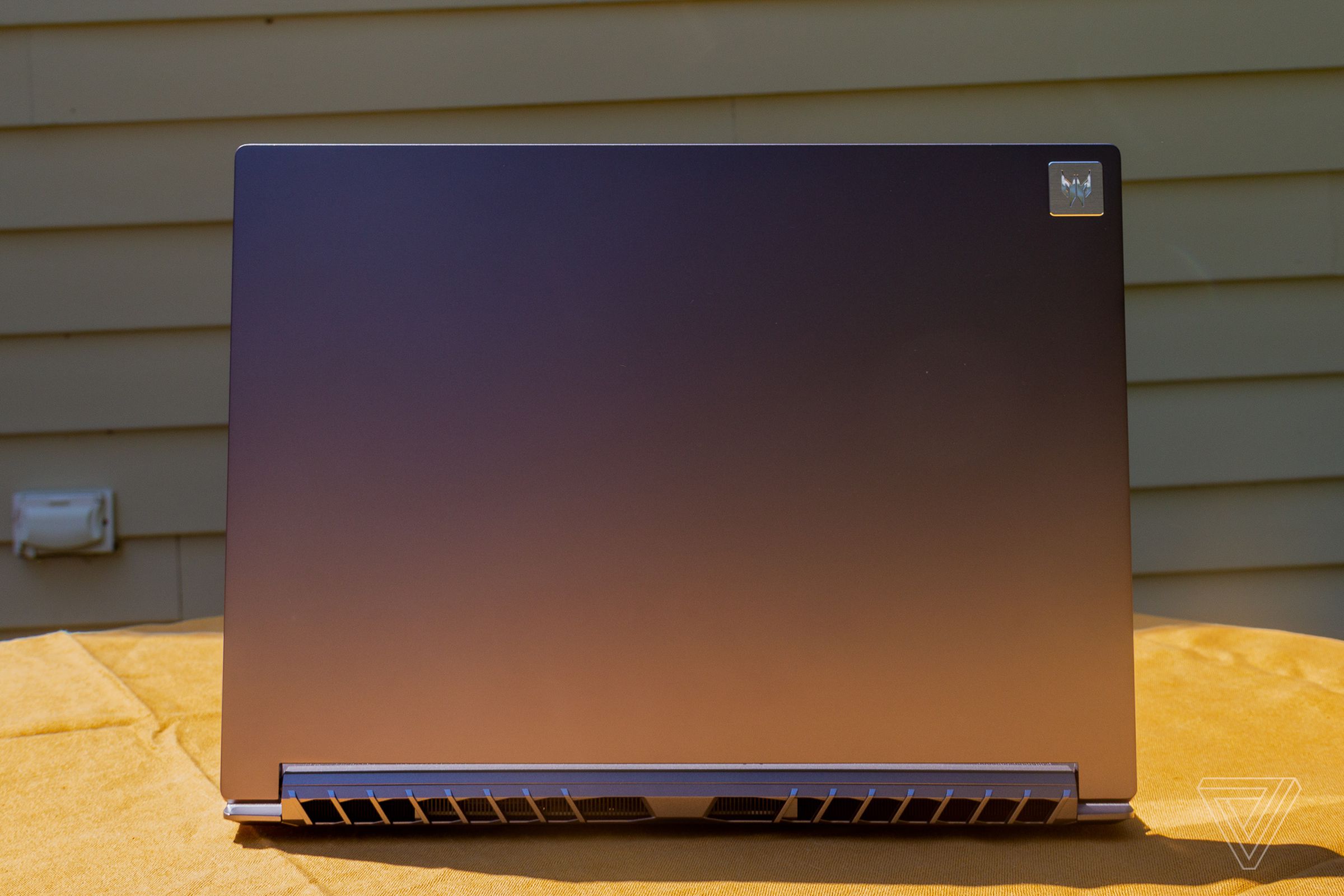 The Acer Predator Triton 500 SE open seen from the back on a yellow tablecloth.