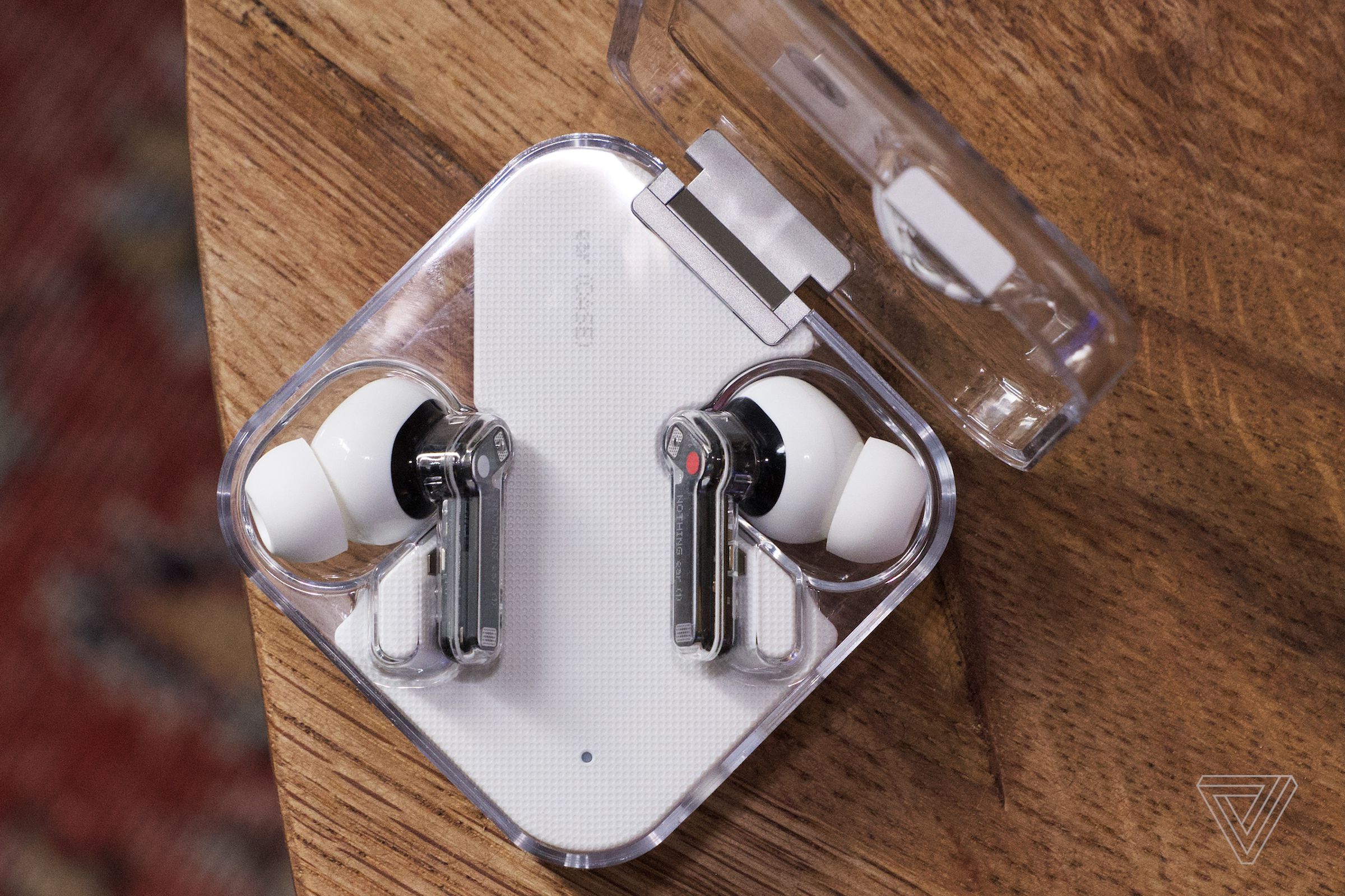 The earbuds lay flat in the charging case.