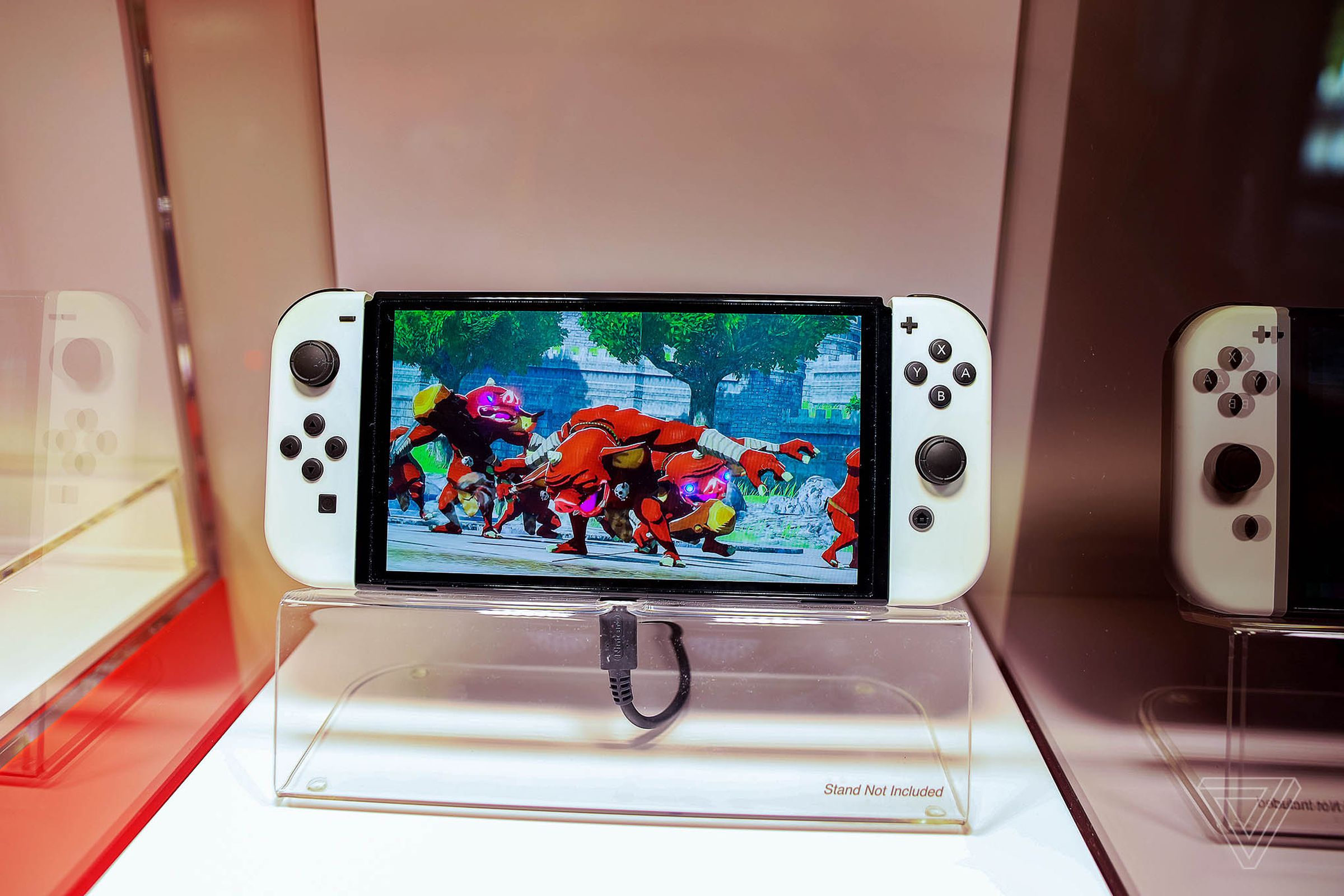 A hand holding the Nintendo Switch OLED.