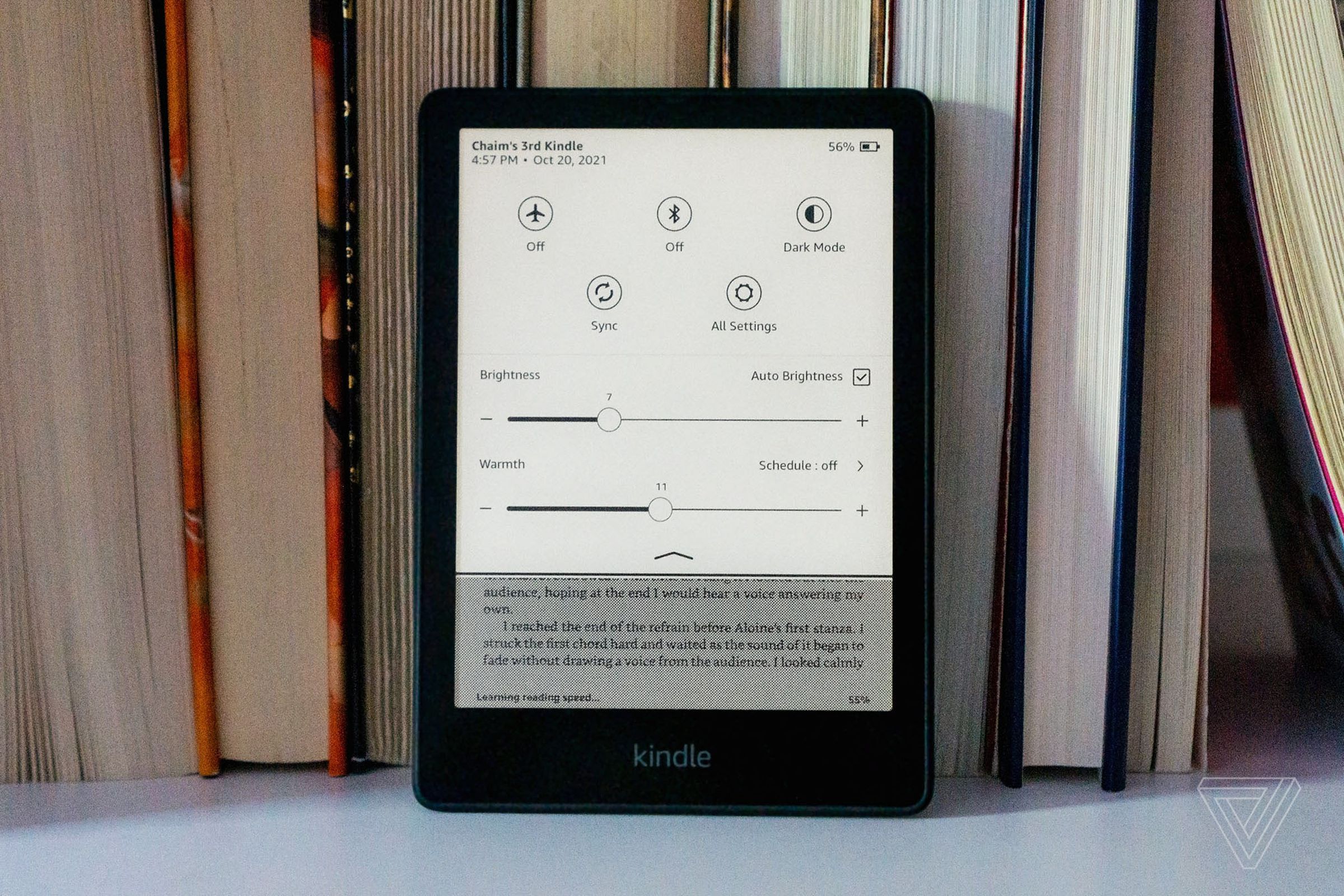 The Kindle Paperwhite in front of a stack of books.