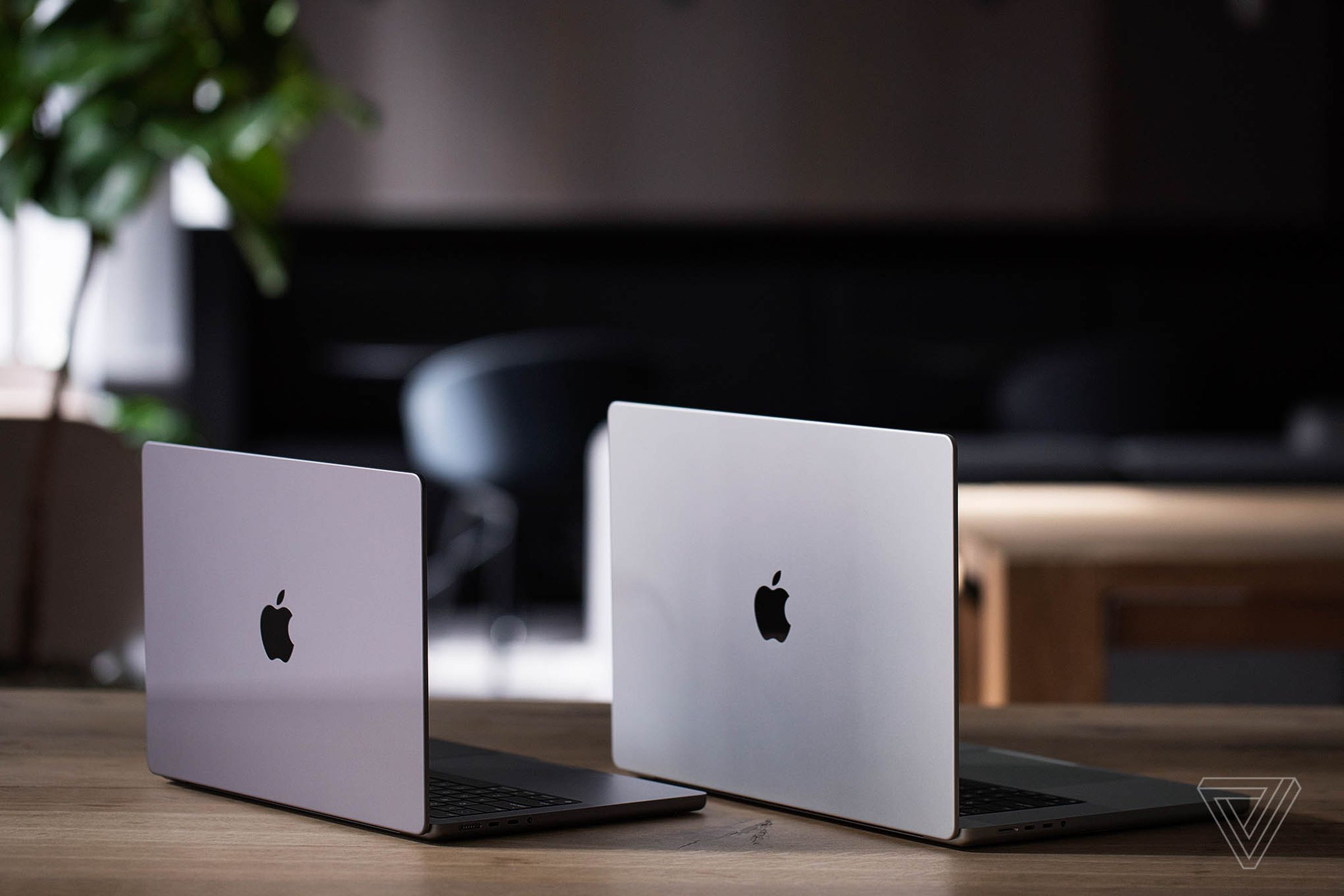 The back of a space gray MacBook Pro 14 next to the back of a silver MacBook Pro 16.