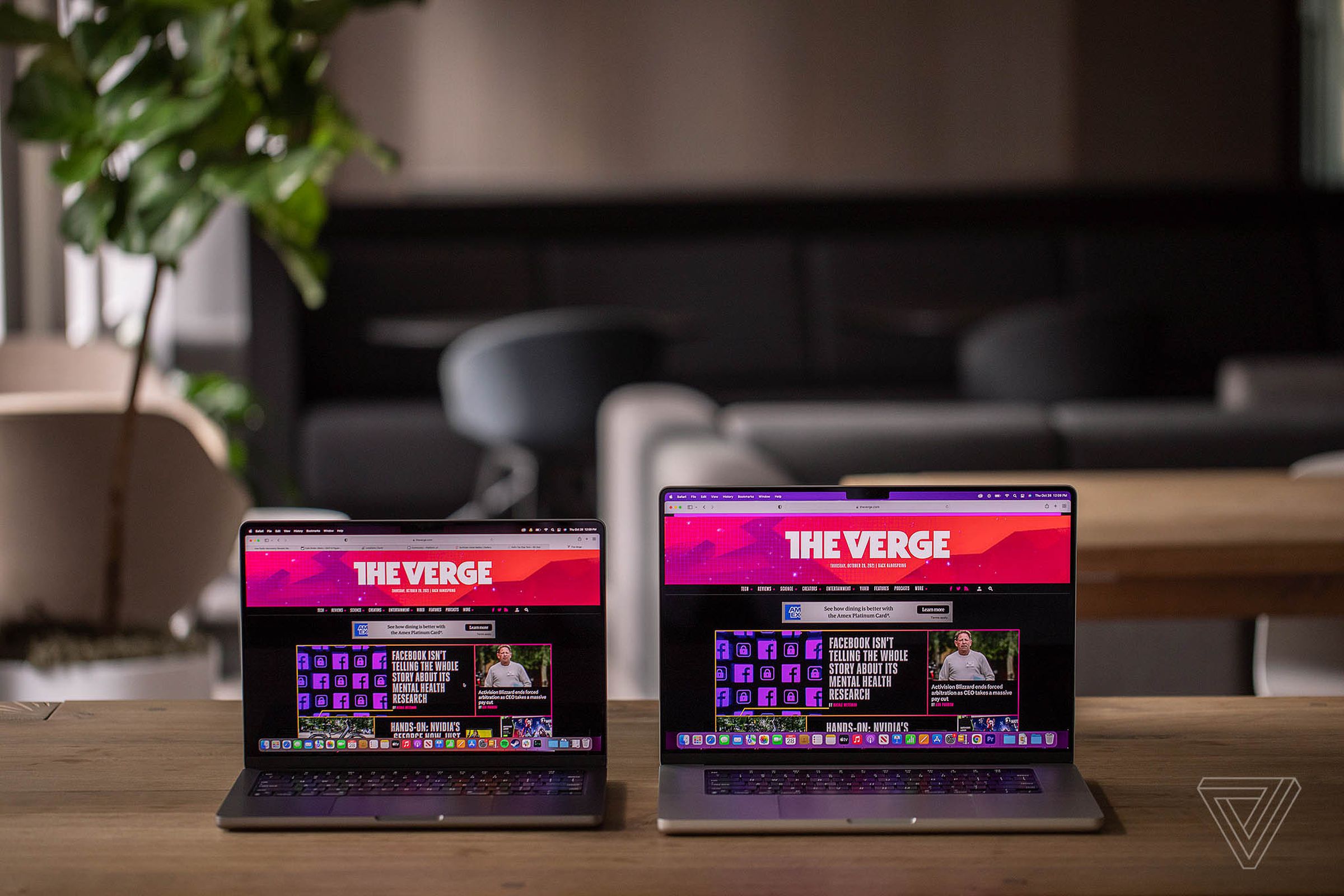 MacBook Pro 14 và MacBook Pro 16 đặt cạnh nhau trên bàn, cả hai đều hiển thị trang chủ The Verge.