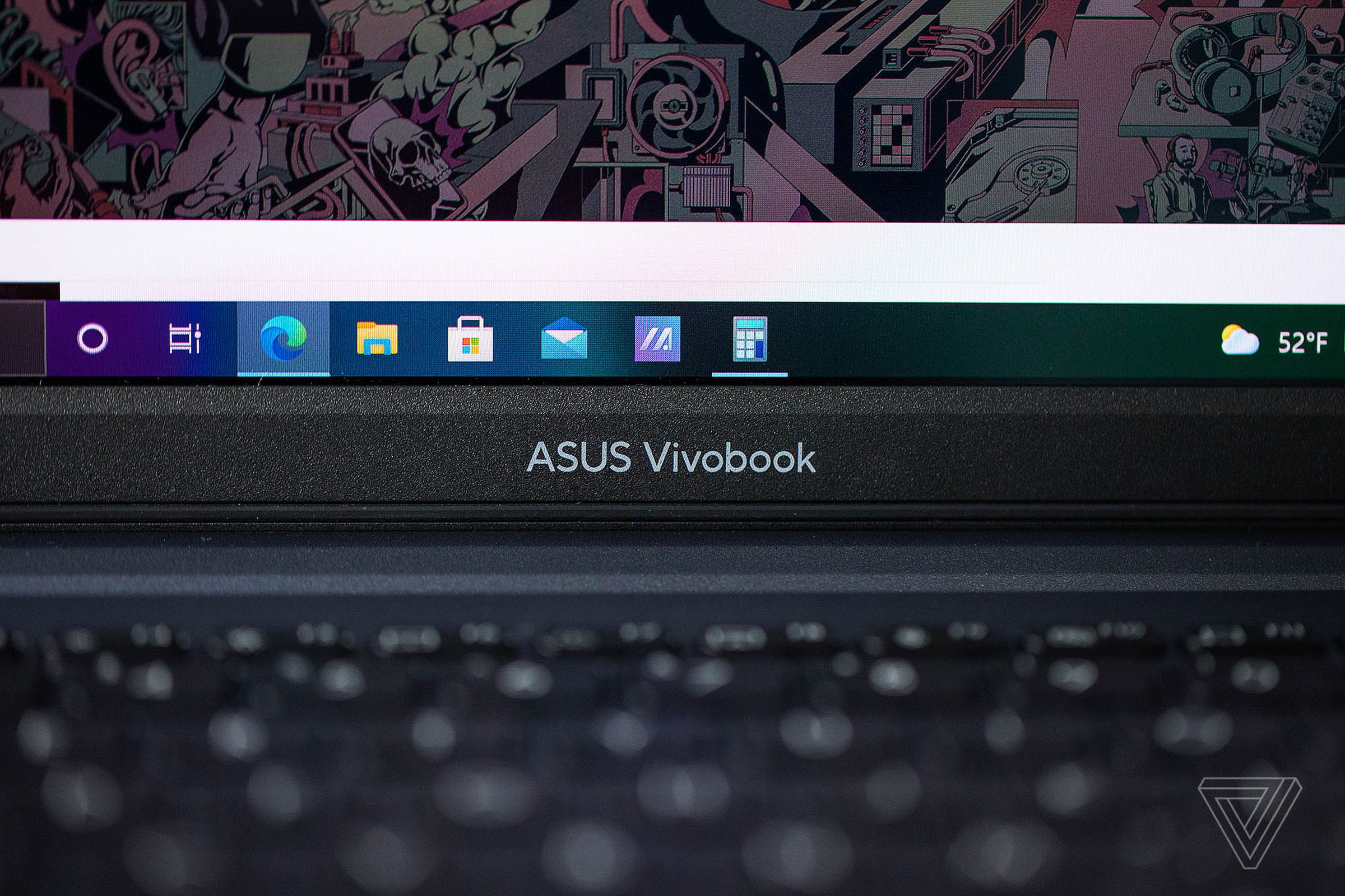 The Asus Vivobook logo on the bottom bezel of the Asus Vivobook Pro 14, up close.