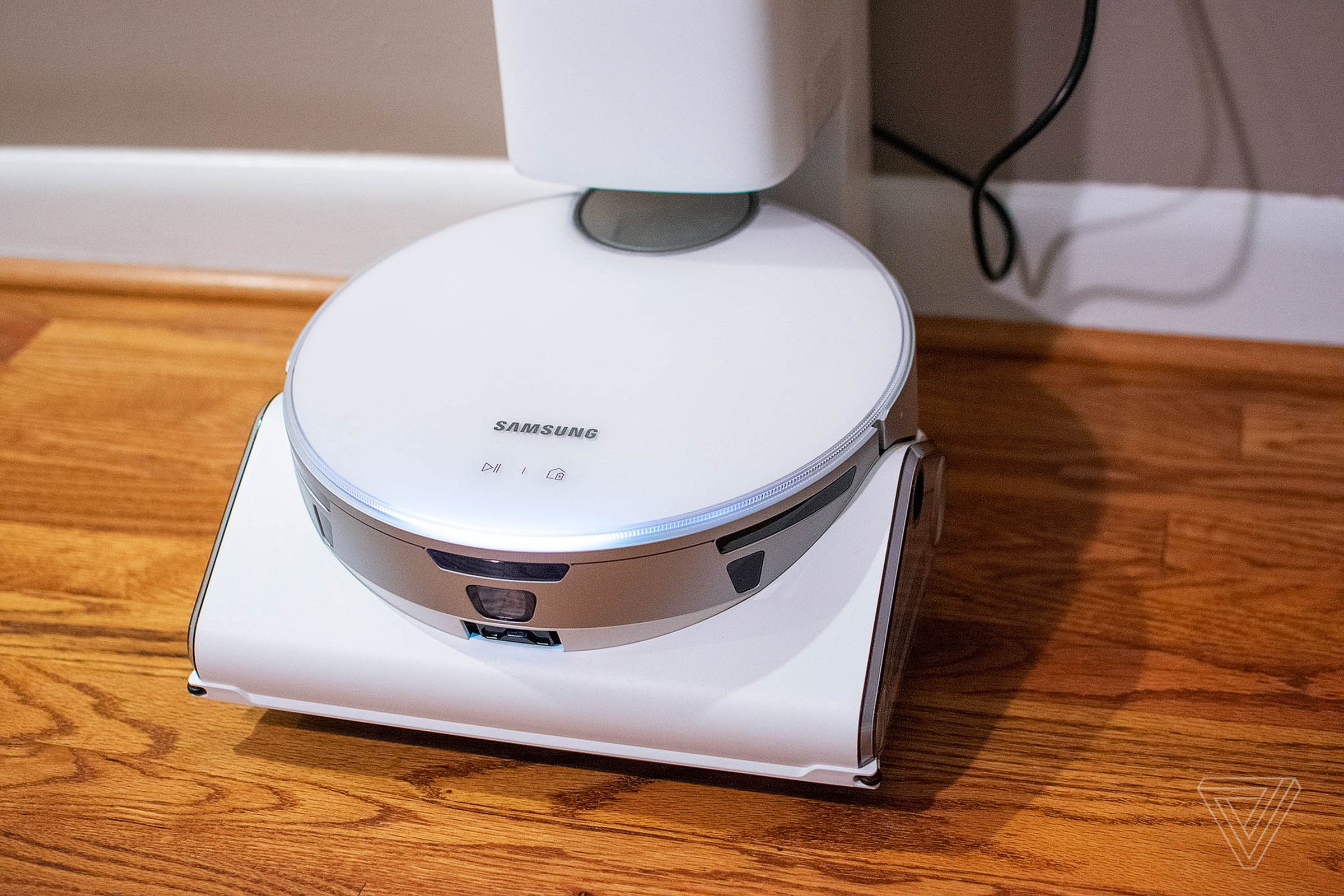 The Samsung Jet Bot AI Plus is a sleek, all-white affair with a robot-like LED eye that glows, indicating what state the vacuum is in.