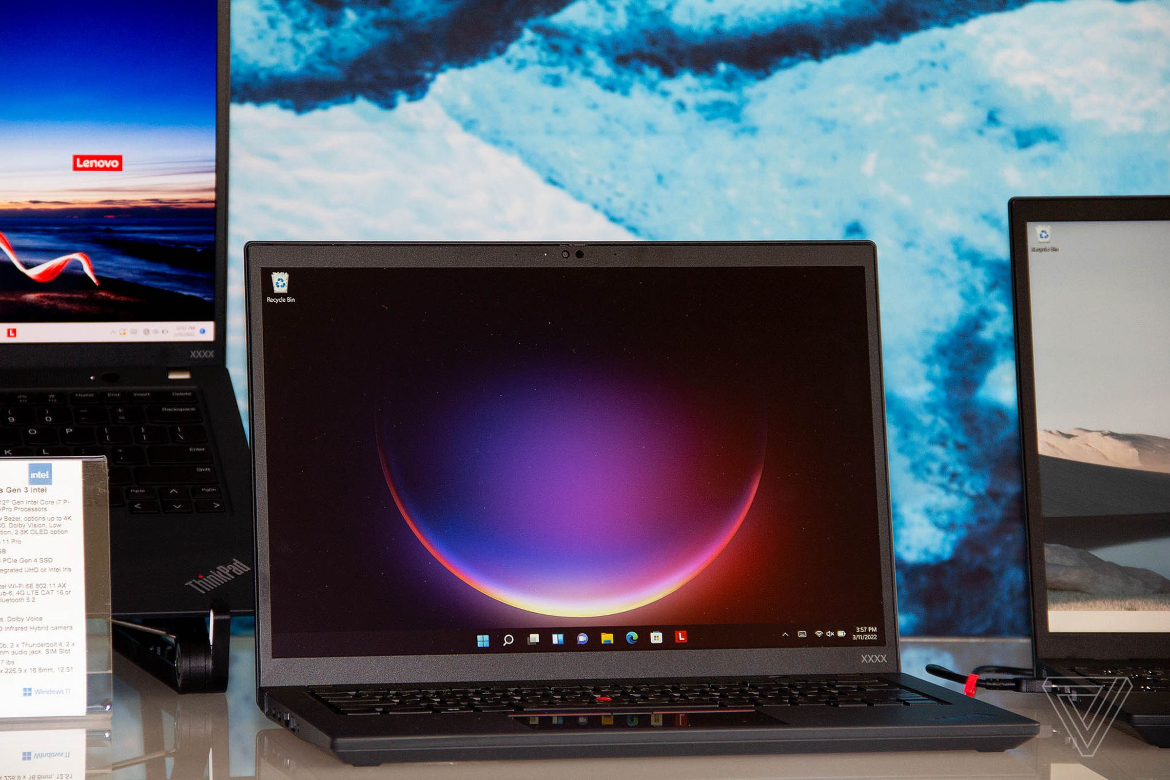 The Lenovo ThinkPad T14s open on a white table angled to the right. The screen displays a crescent moon.