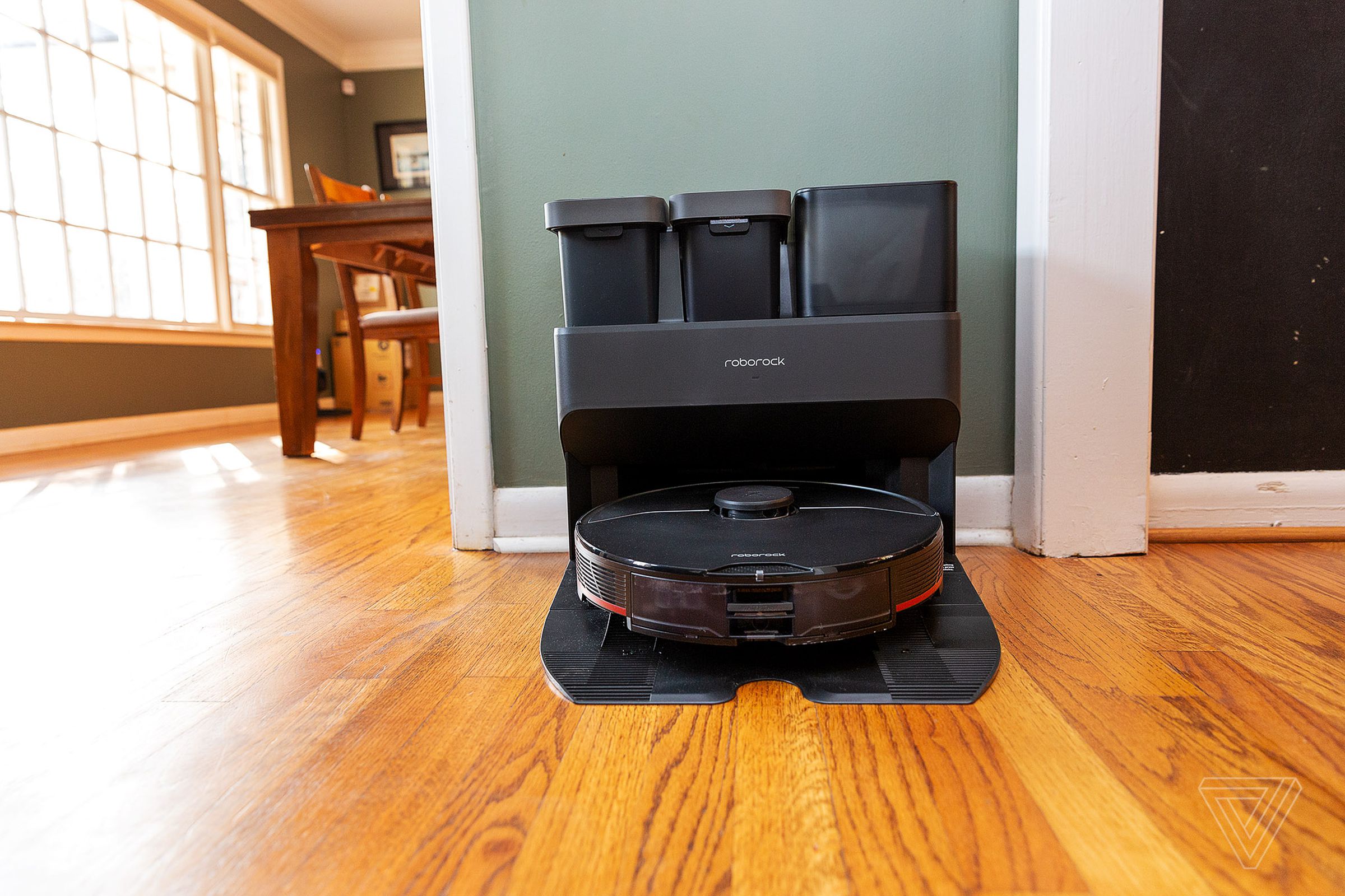 A robot vacuum and its docking station in a living room.