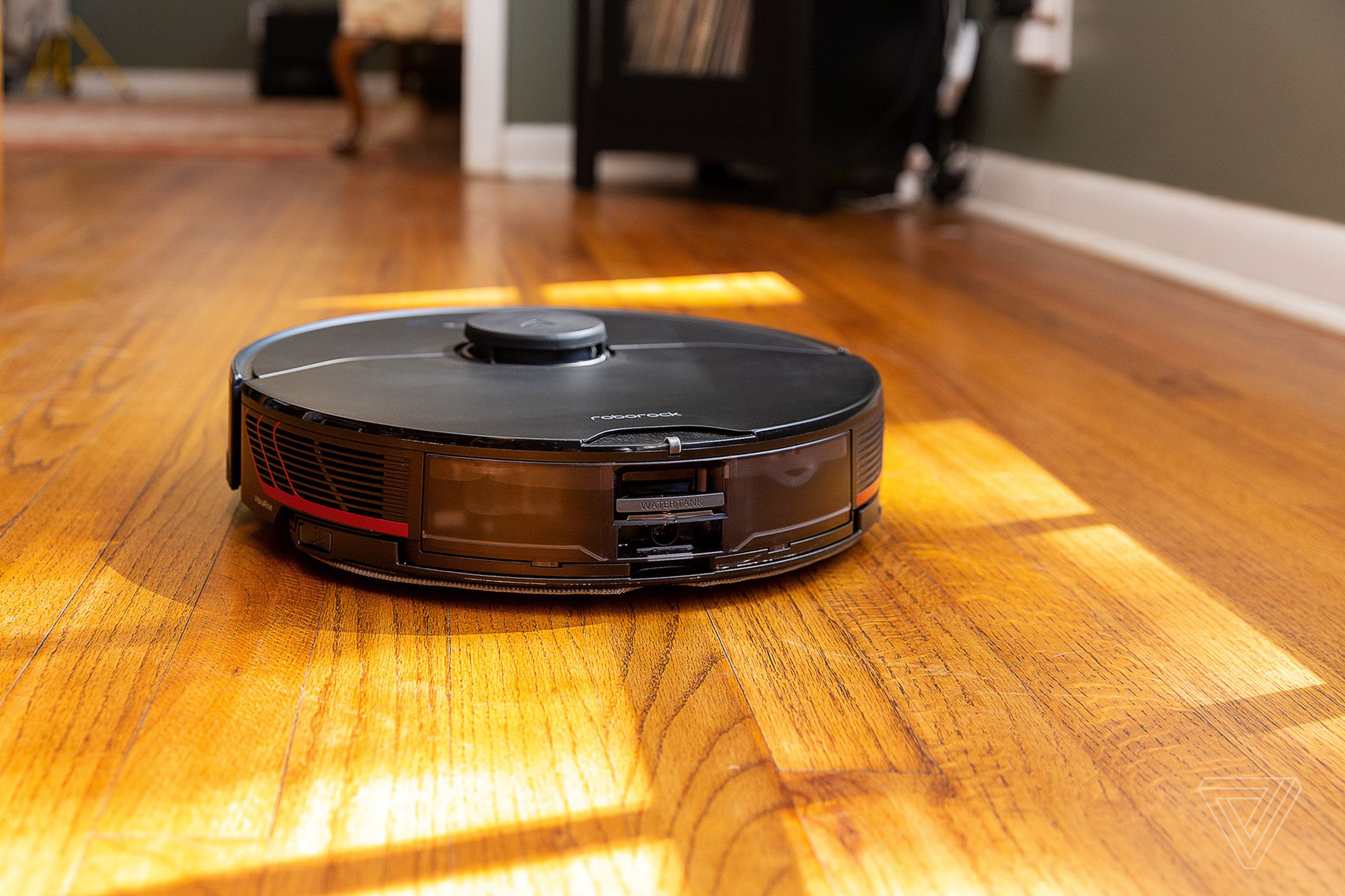 A robot vacuum on a wood floor.