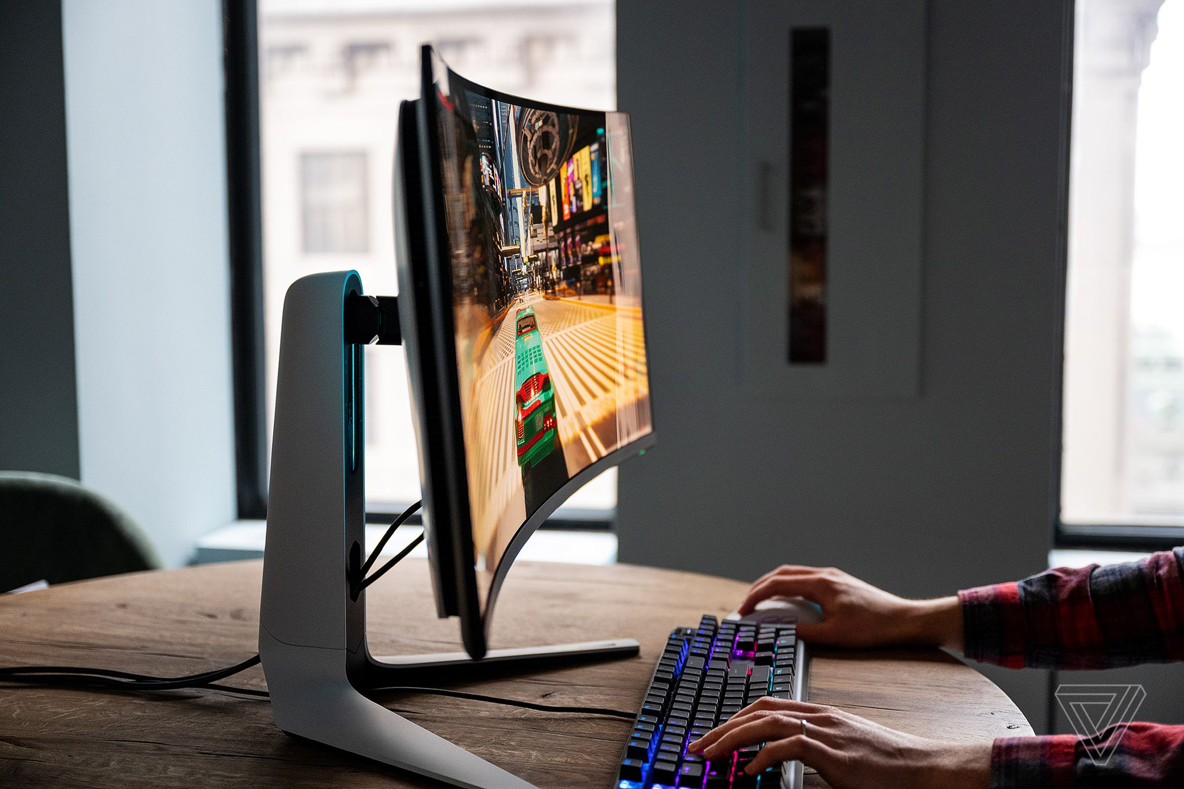 Alienware AW3423DW QD-OLED gaming monitor sitting on a wooden desk displaying the game Cyberpunk 2077