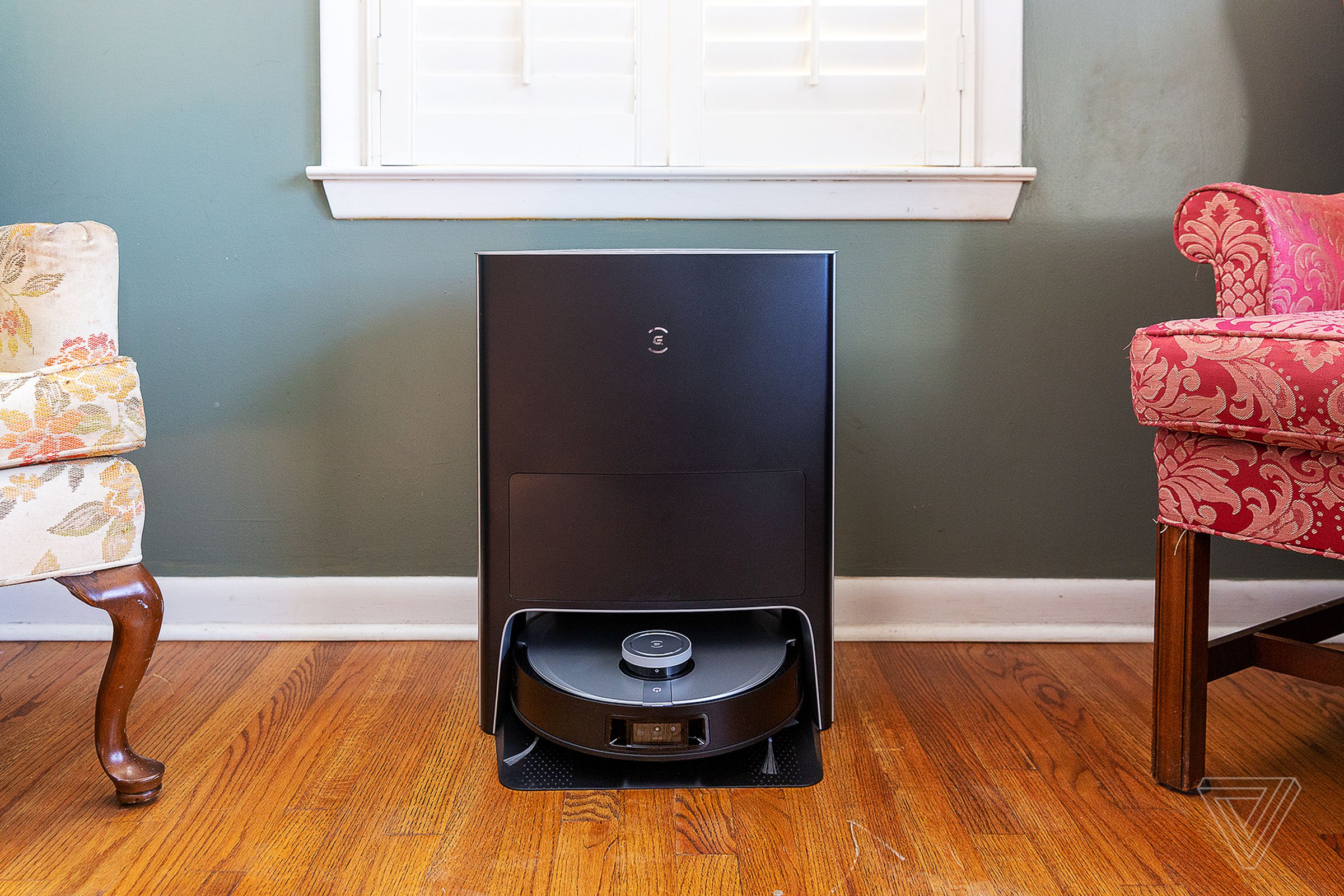 An Ecovacs Deebot X1 Omni robot vacuum, docked in its self-cleaning station in a living room.