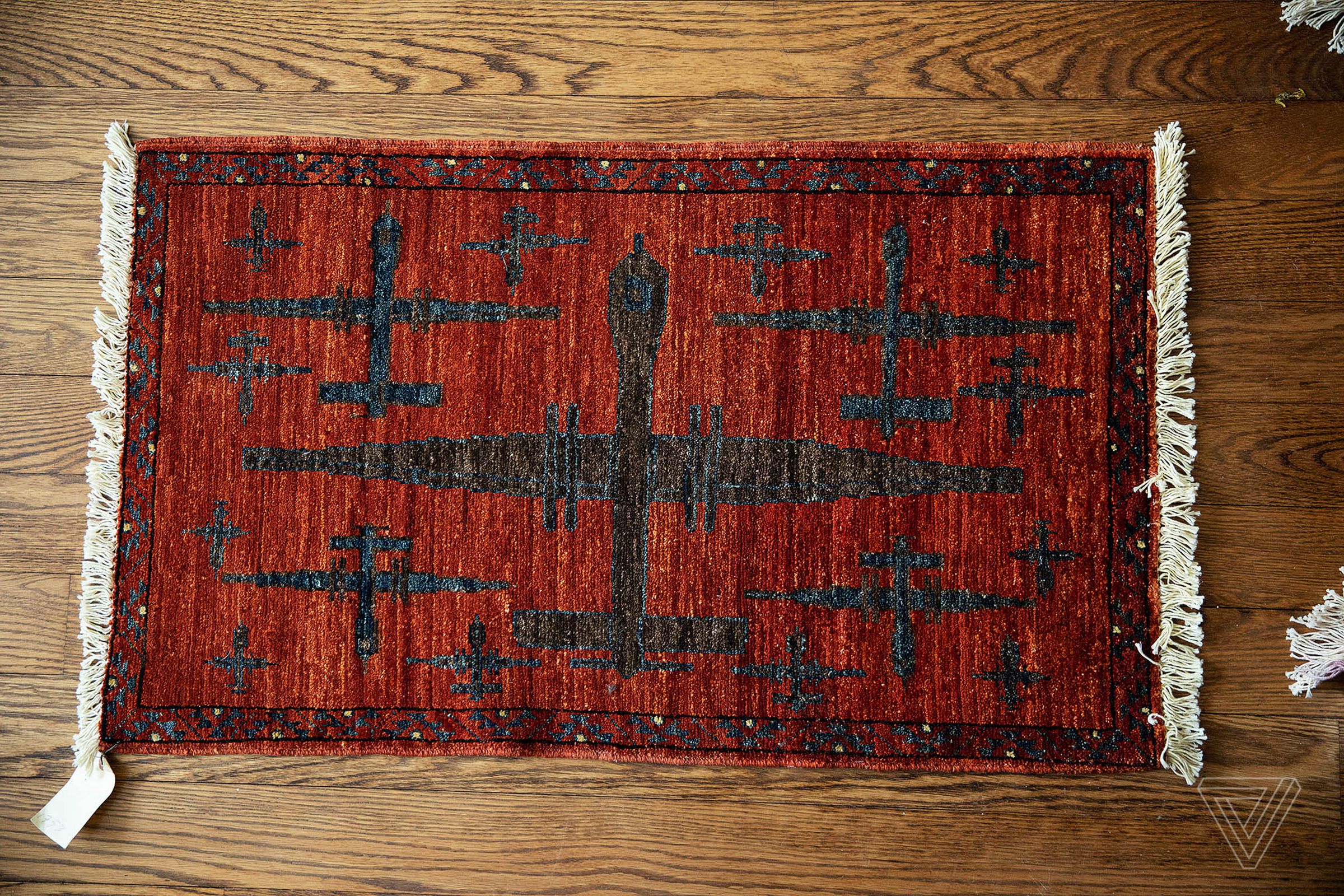 A red rug depicting dark colored drones.