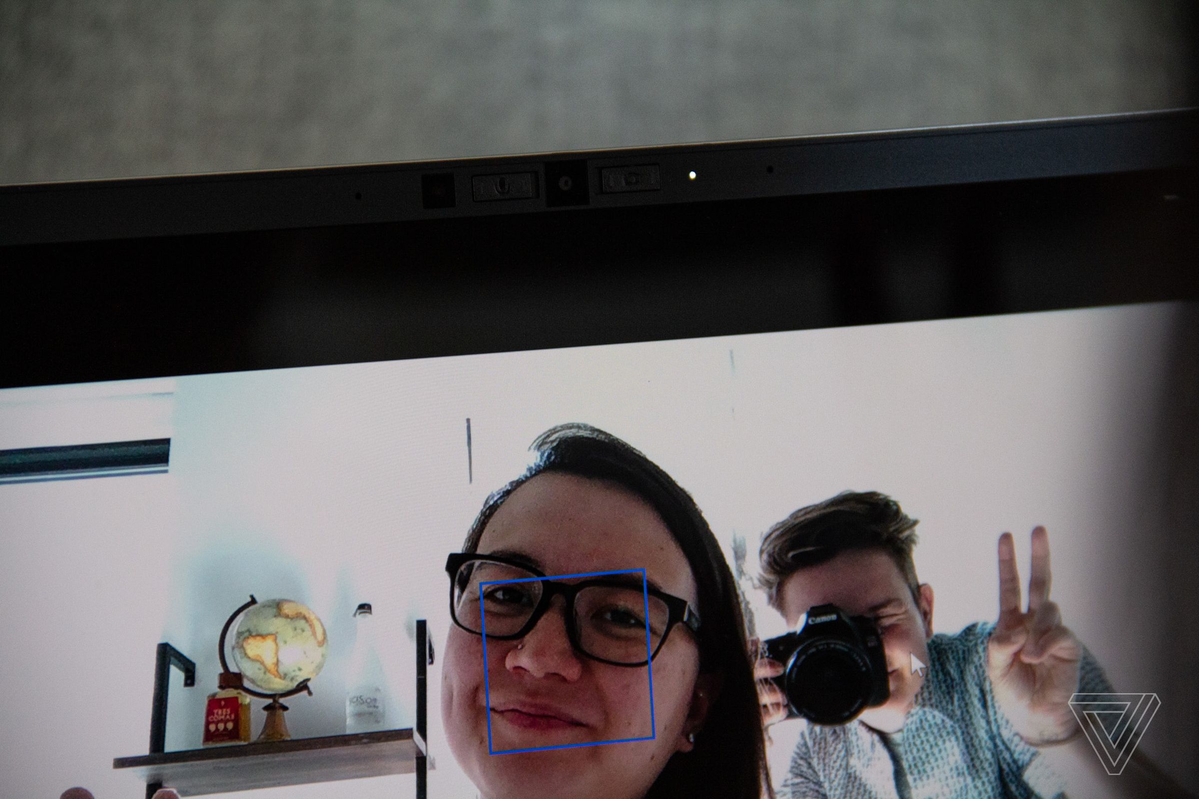Two users seen in a camera utility through the Framework Latptop’s webcam. One smiles and one makes a peace sign.
