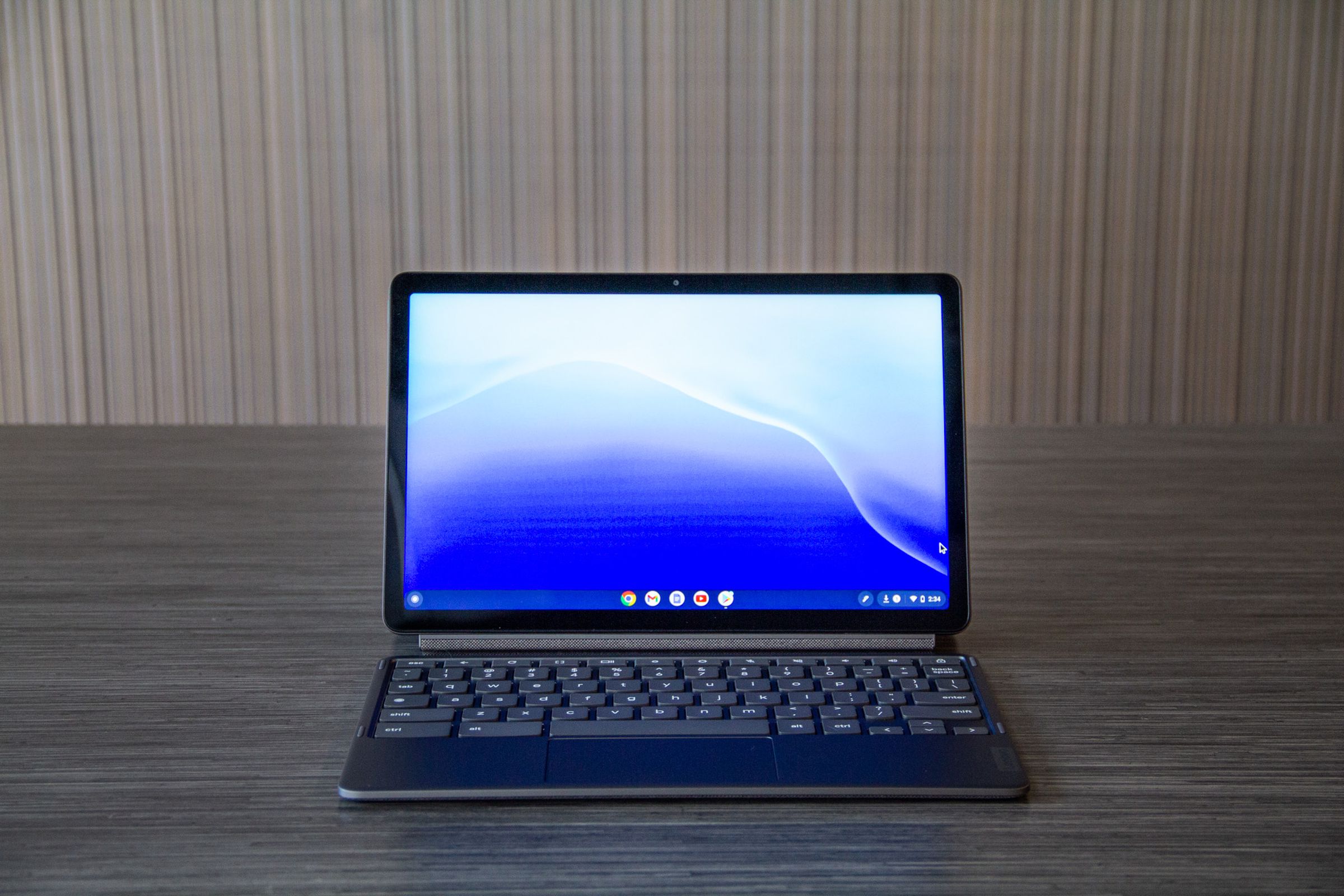 The Lenovo Chromebook Duet from the front in laptop mode. The screen displays a blue desktop background.