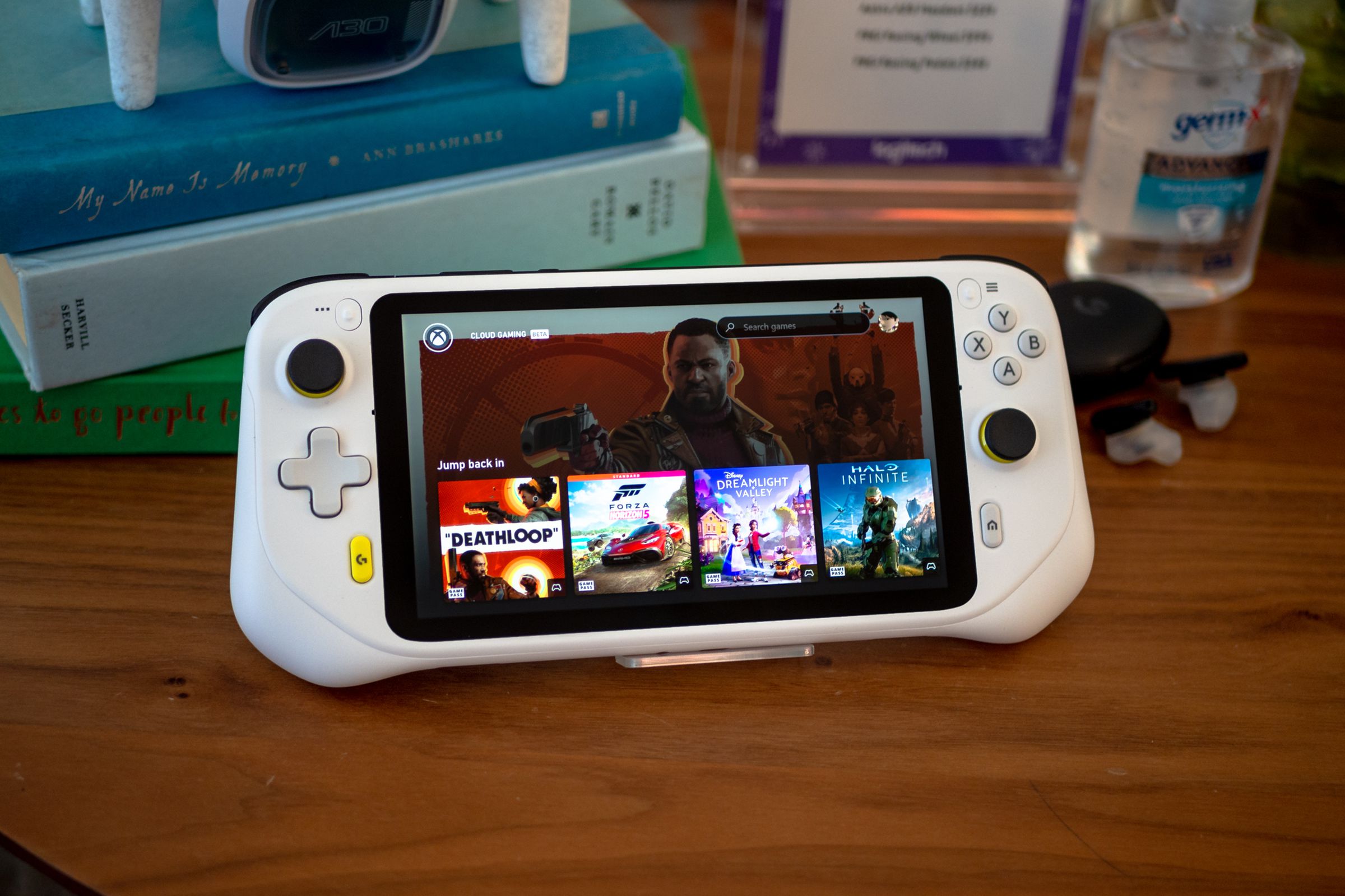 Logitech’s G Cloud Gaming Handheld sitting on a wooden table, displaying the user interface of the Xbox Cloud Gaming app.