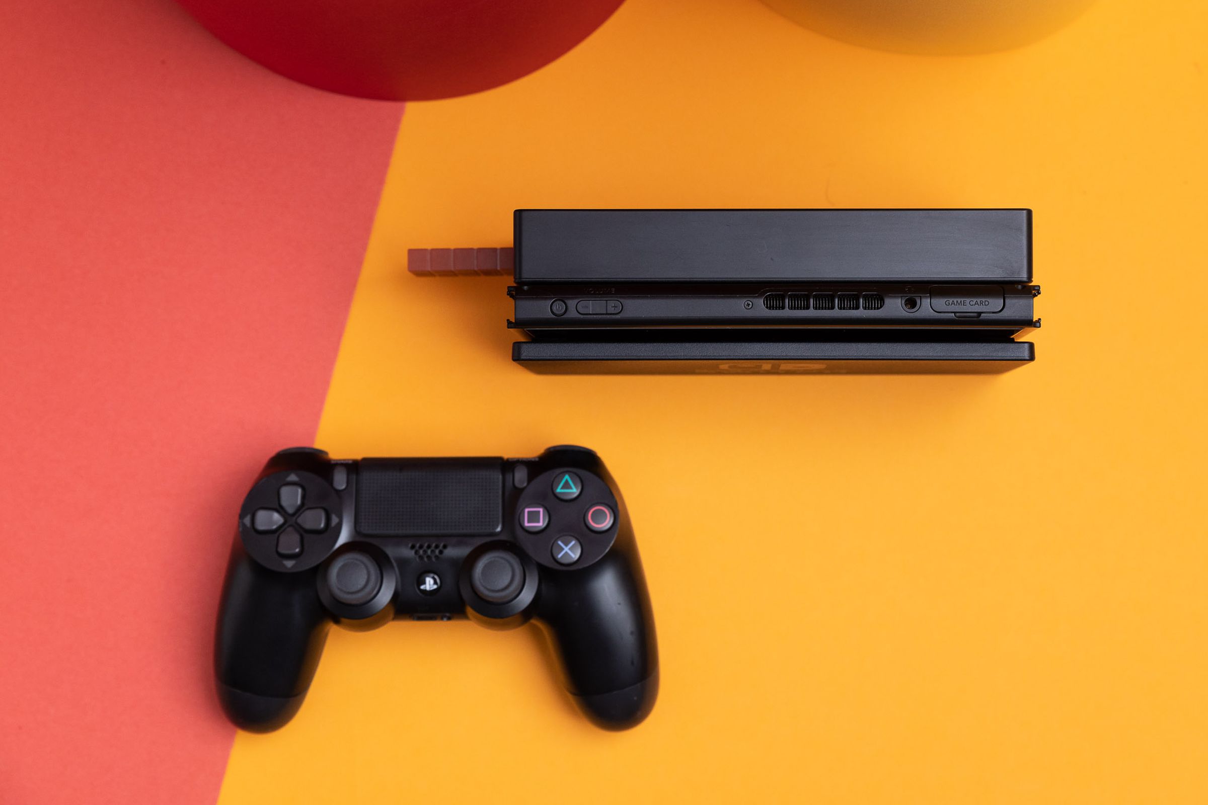 A Nintendo Switch tablet sitting inside of its dock. Next to it is Sony’s DualShock 4 controller, which can be used with the Switch by way of the 8BitDo USB Adapter.