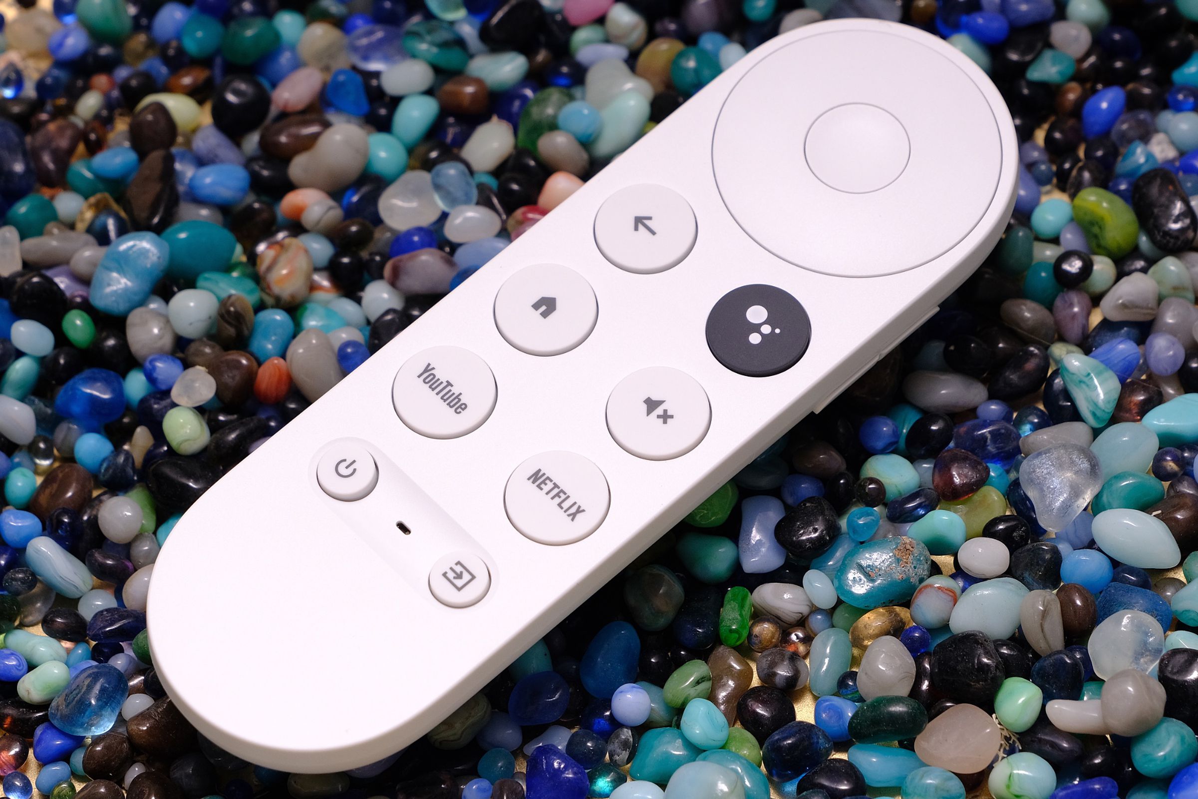An image of the Chromecast with Google TV remote on top of various colored stones.