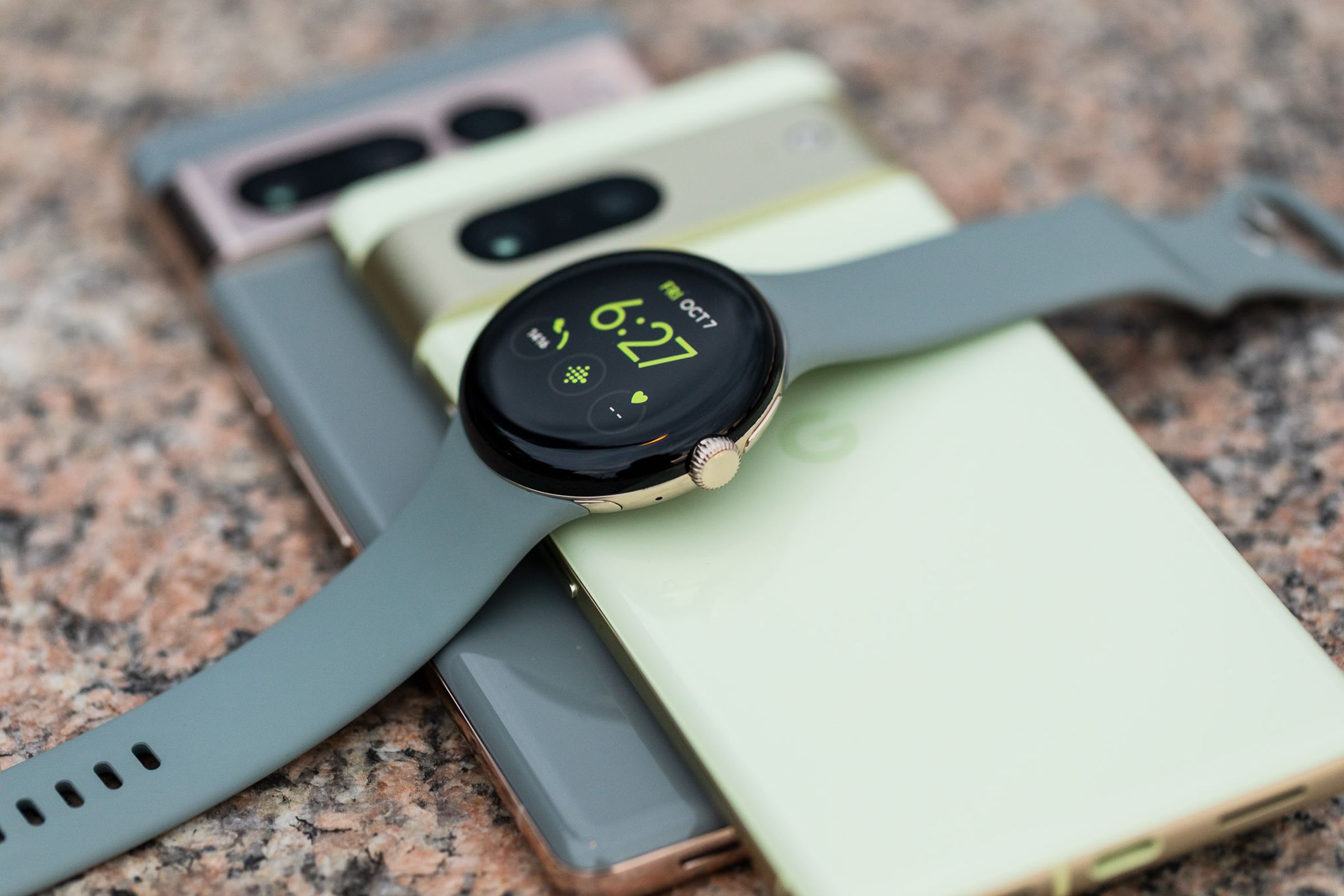 Pixel 7 ve Pixel 7 Pro telefonların üzerine örtülmüş bir açıyla Pixel Watch
