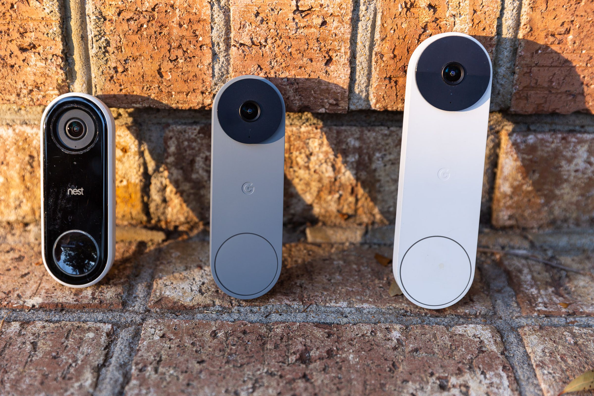 Three video doorbells on a brick step