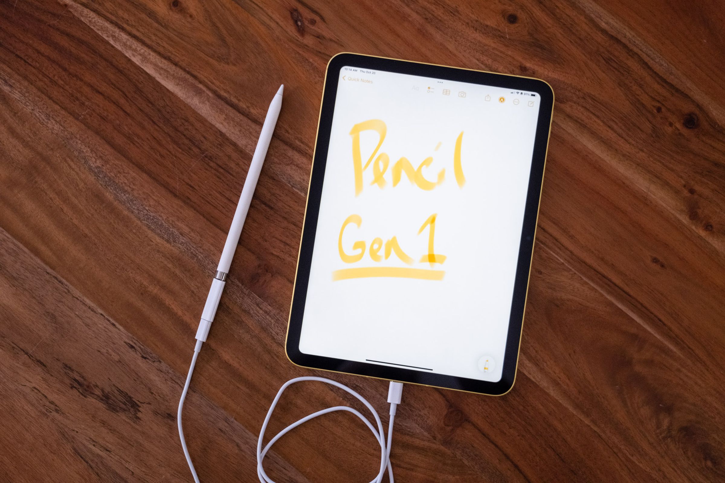 A first generation Apple Pencil plugged into a 10th gen iPad via the USB-C to lightning adapter and a USB-C cable.