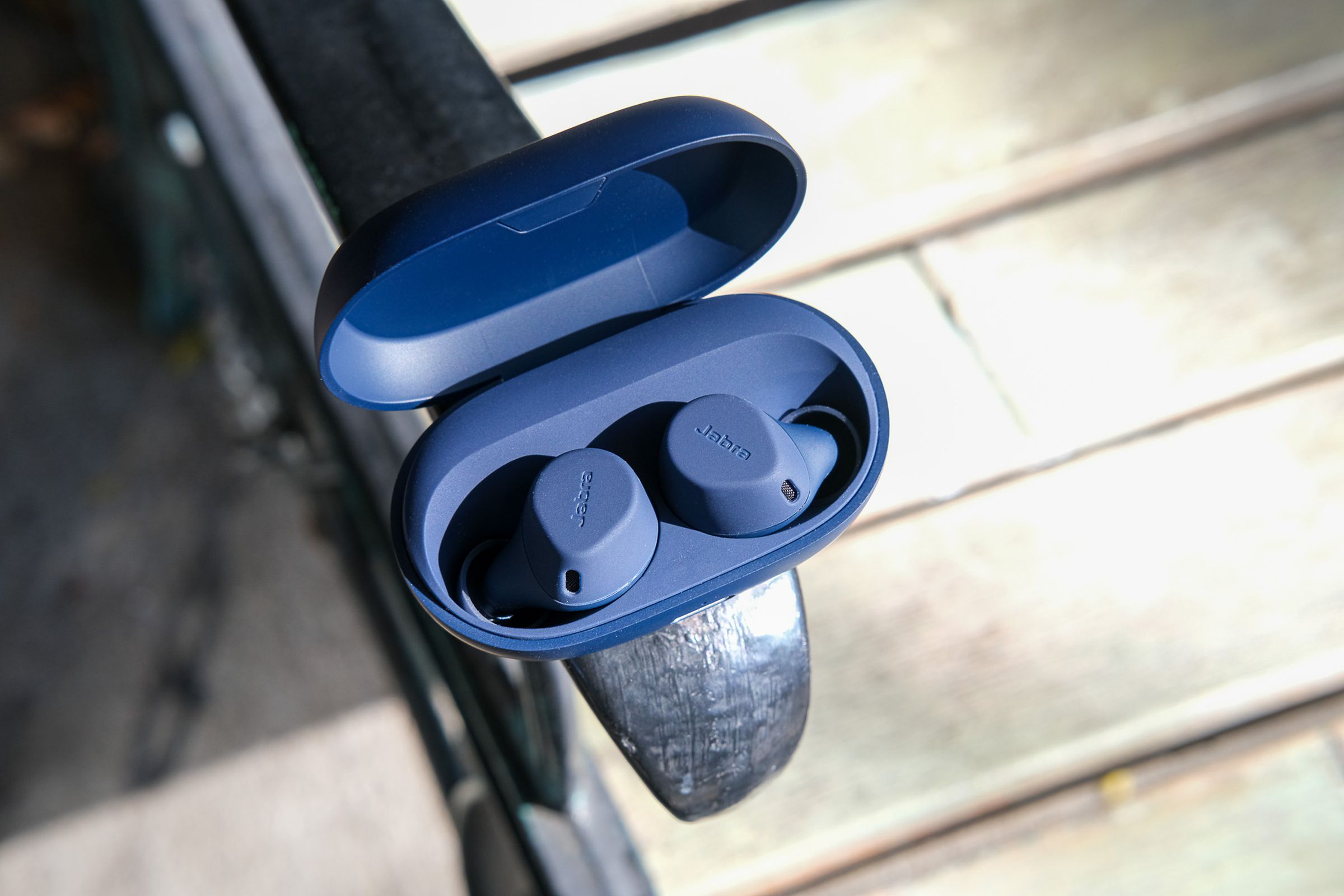 An image of Jabra’s Elite 7 Active earbuds photographed on a bench.