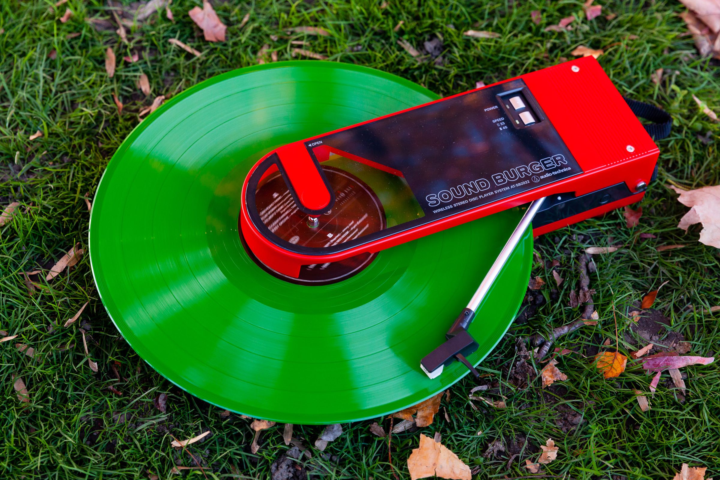 The Soundburger lays in the grass playing a green record