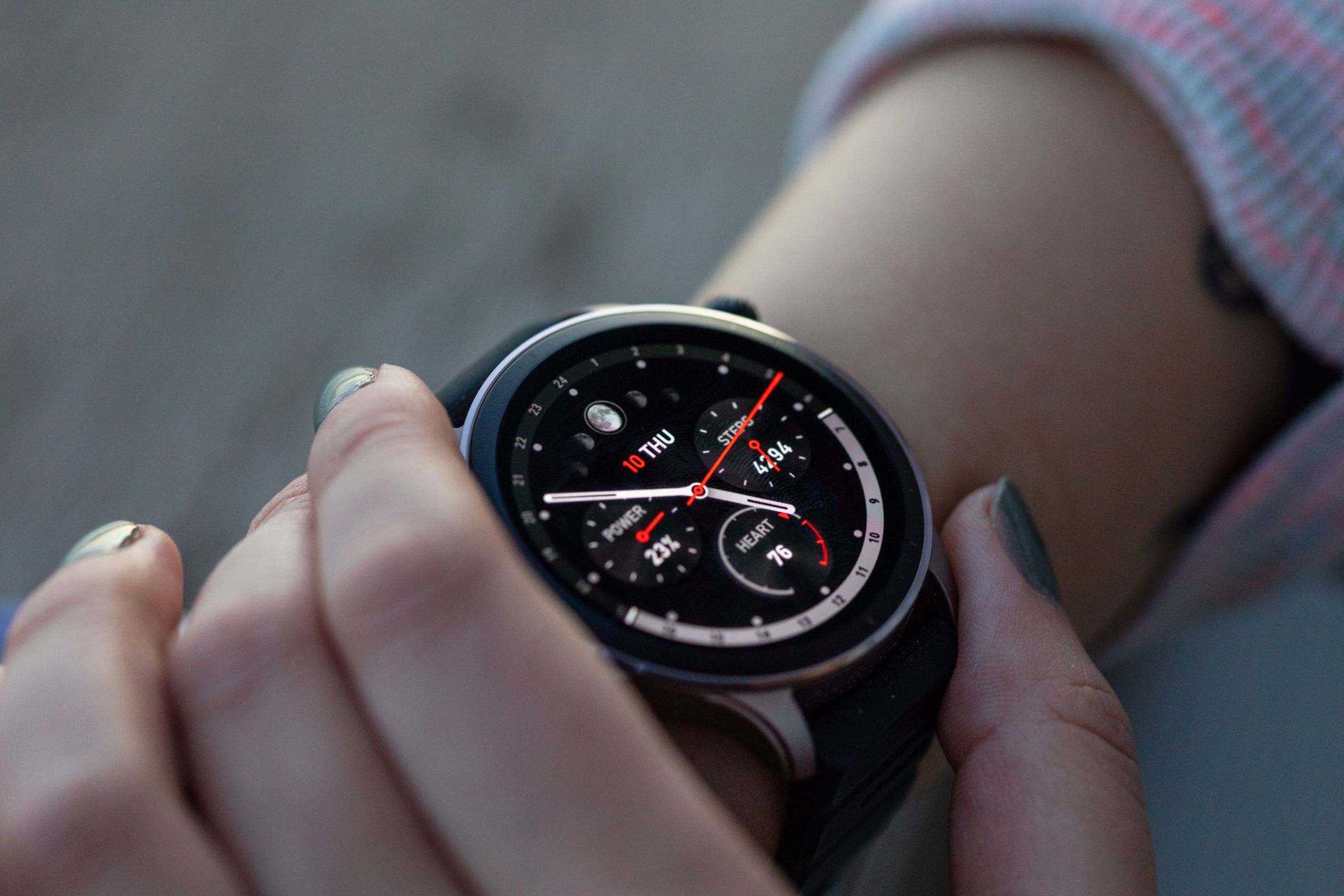 Amazfit GTR 4 on a woman’s wrist with a closeup of an analog watch face
