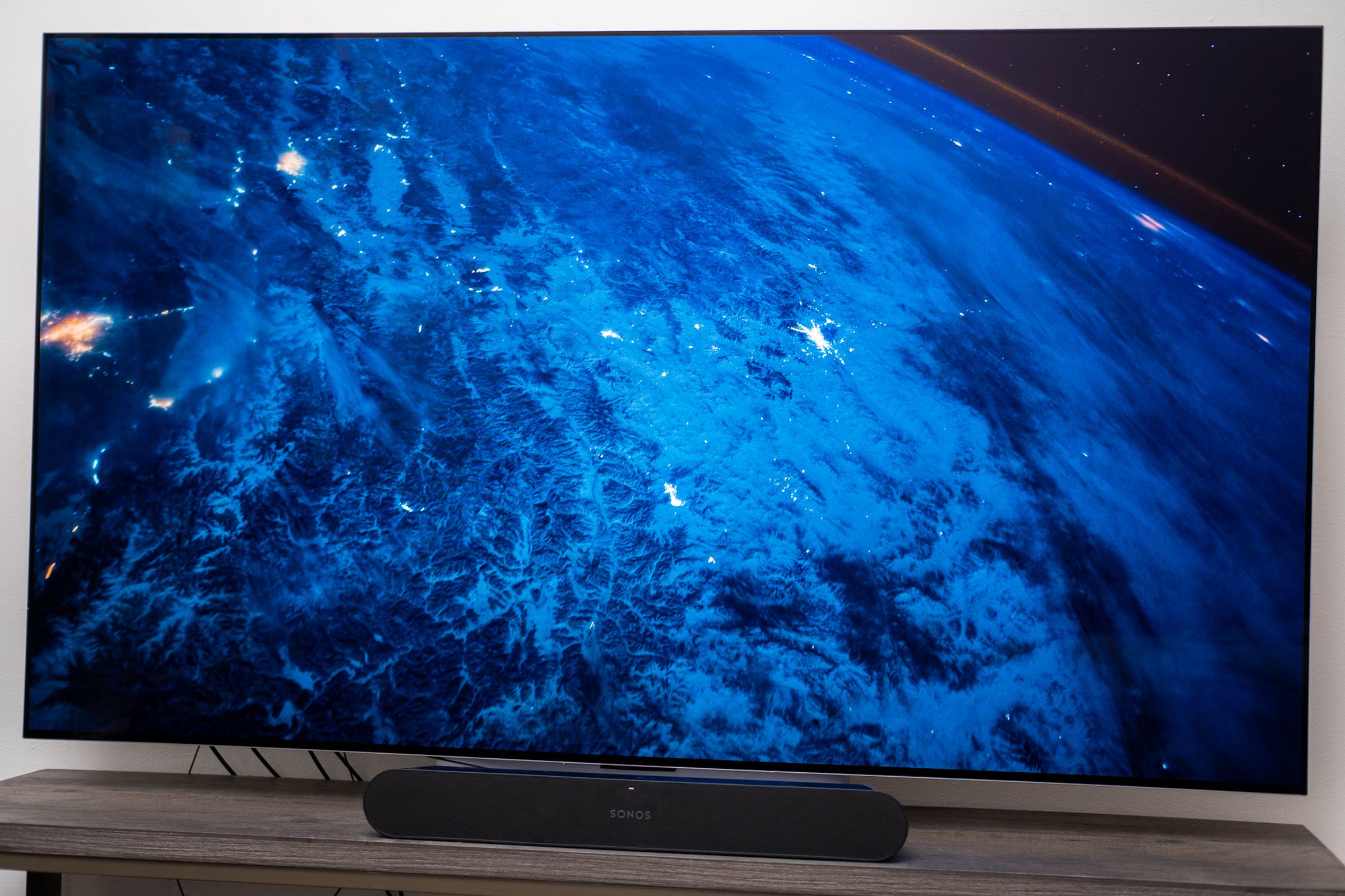 A photo of the LG C2 OLED TV displaying a screensaver of the Earth.