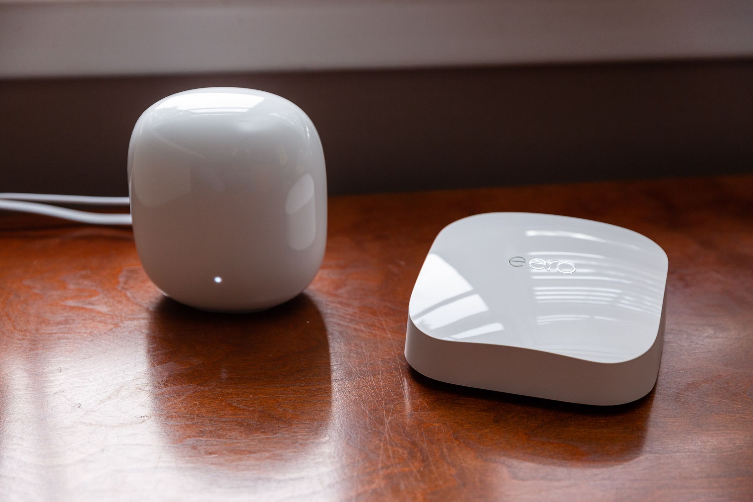 Nest Wifi Pro router on a table next to an Eero router.