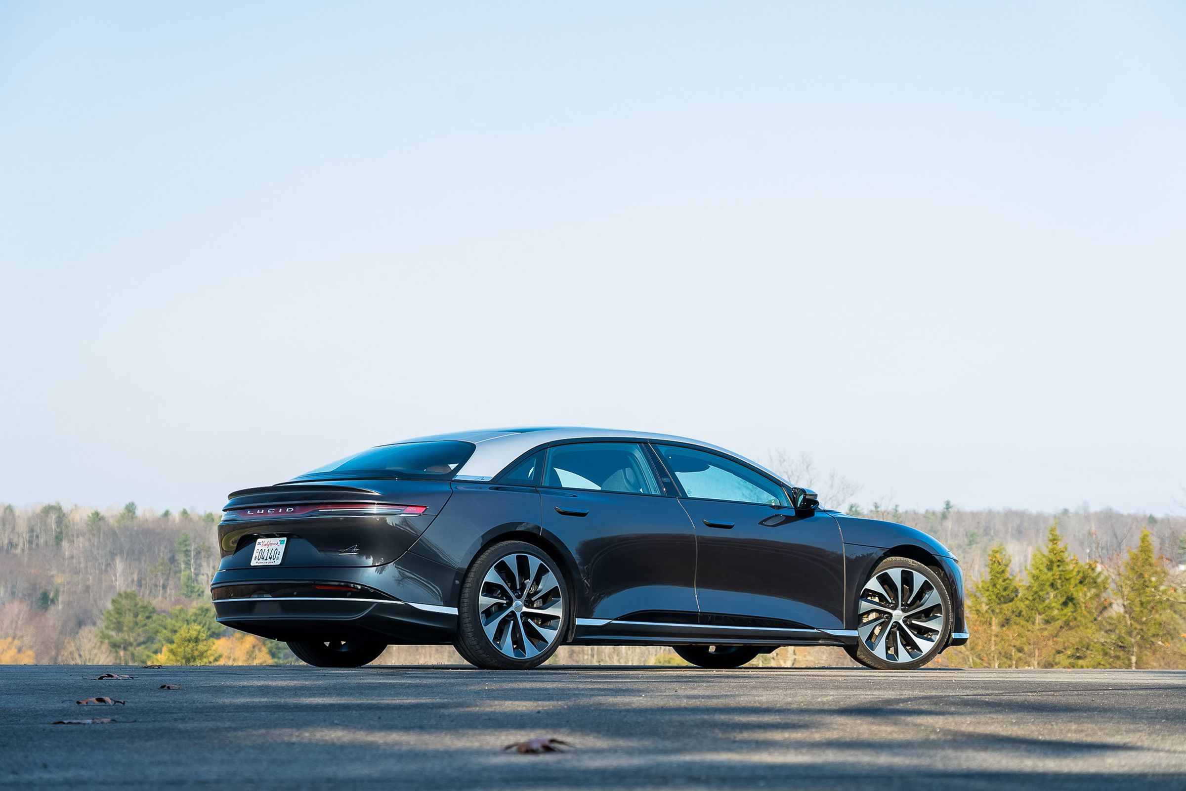 Lucid Air, low angle, rear and passenger side, bright sky, grassy plains