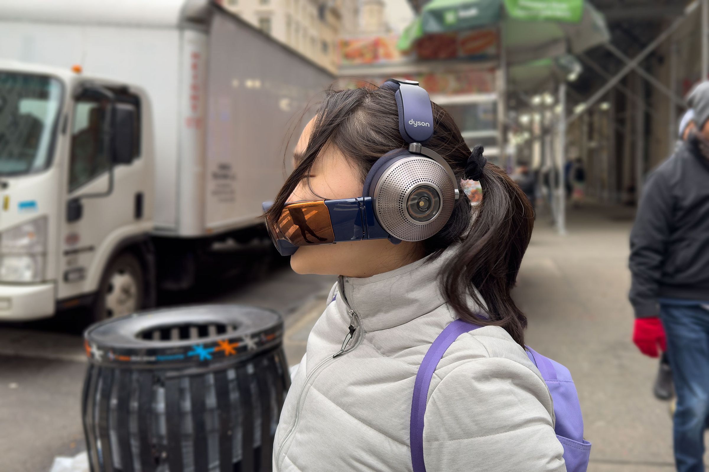 Side view of a woman wearing the Dyson Zone headphones and visor in New York City