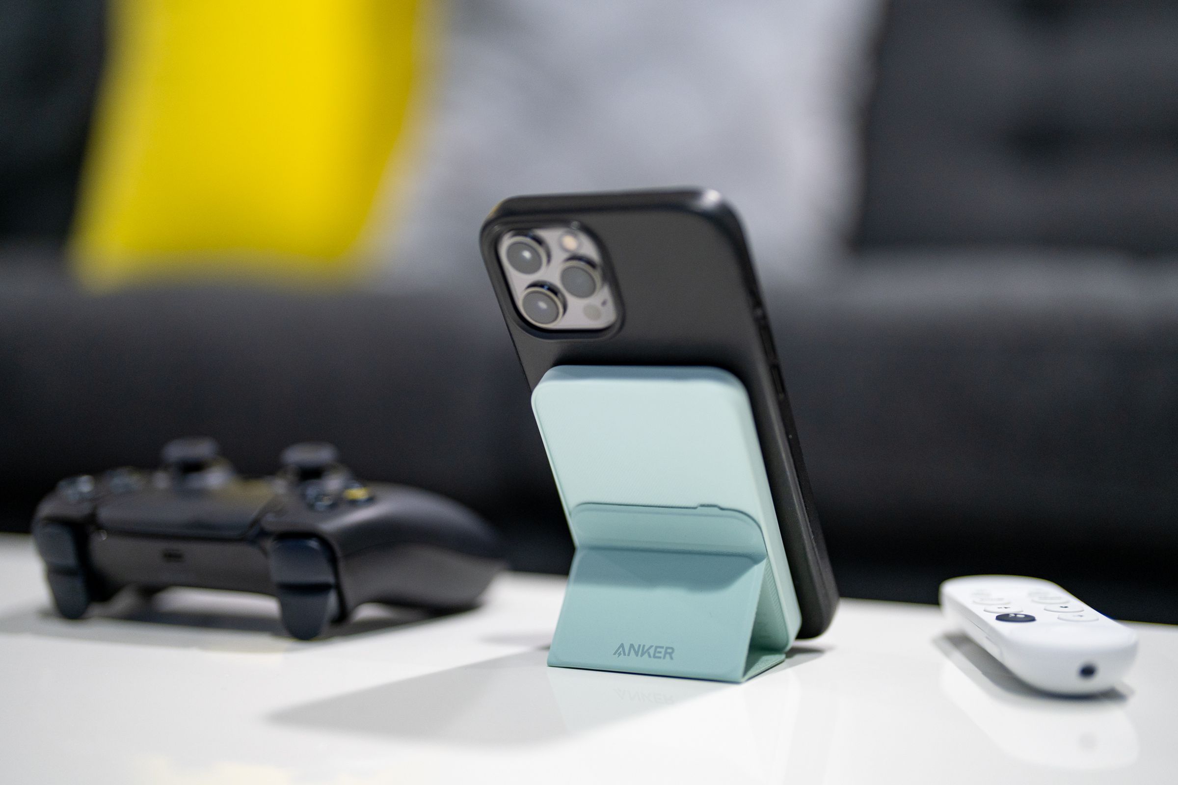 Anker’s 622 Magnetic Battery (MagGo) holding up an iPhone with its kickstand on a desk.