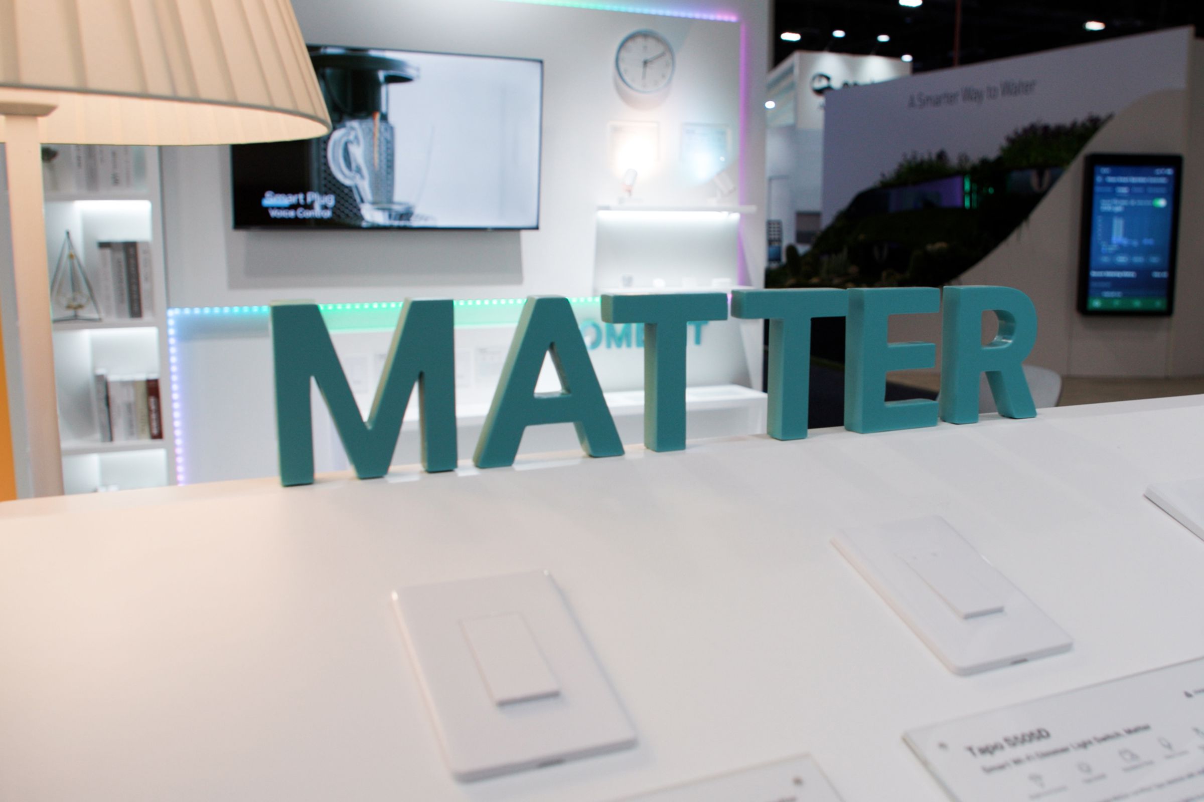 A green Matter sign above smart switches in a booth on the trade show floor.