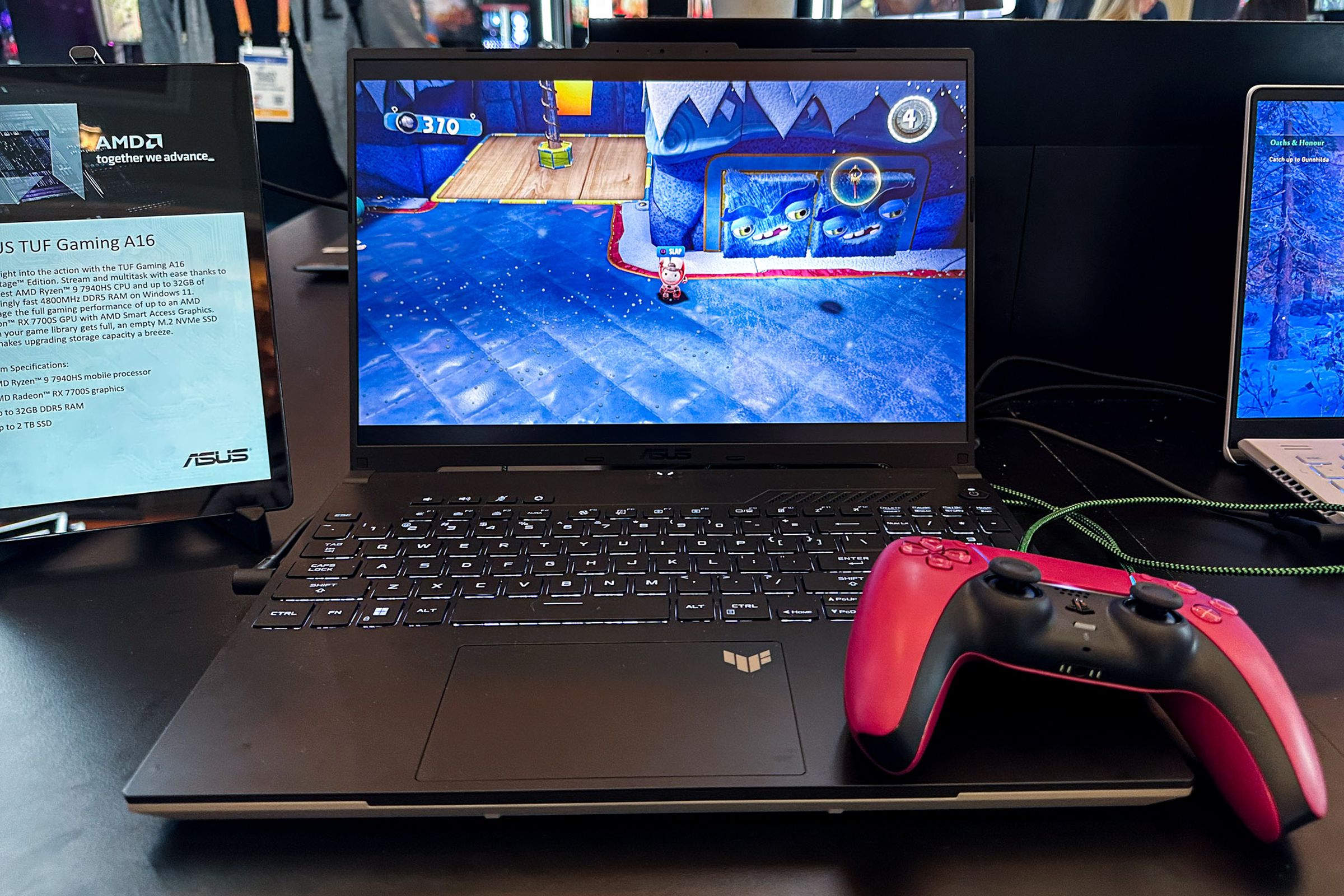 The Asus TUF Gaming A16 running Sack Boy with a red PS5 controller resting on the palm rest.