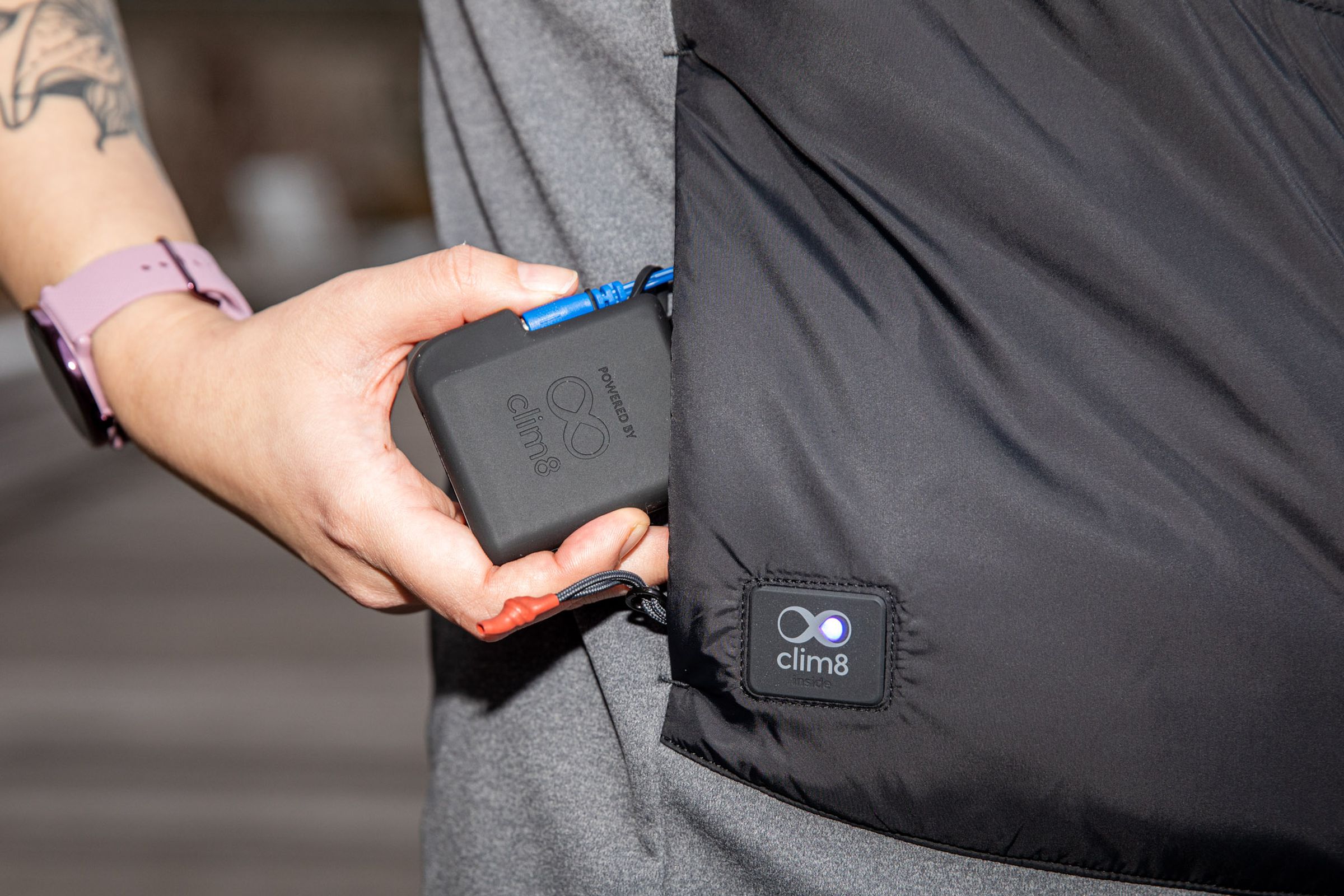 Close-up of person pulling Carhartt X-1 Smart Heated Vest battery out of the pocket