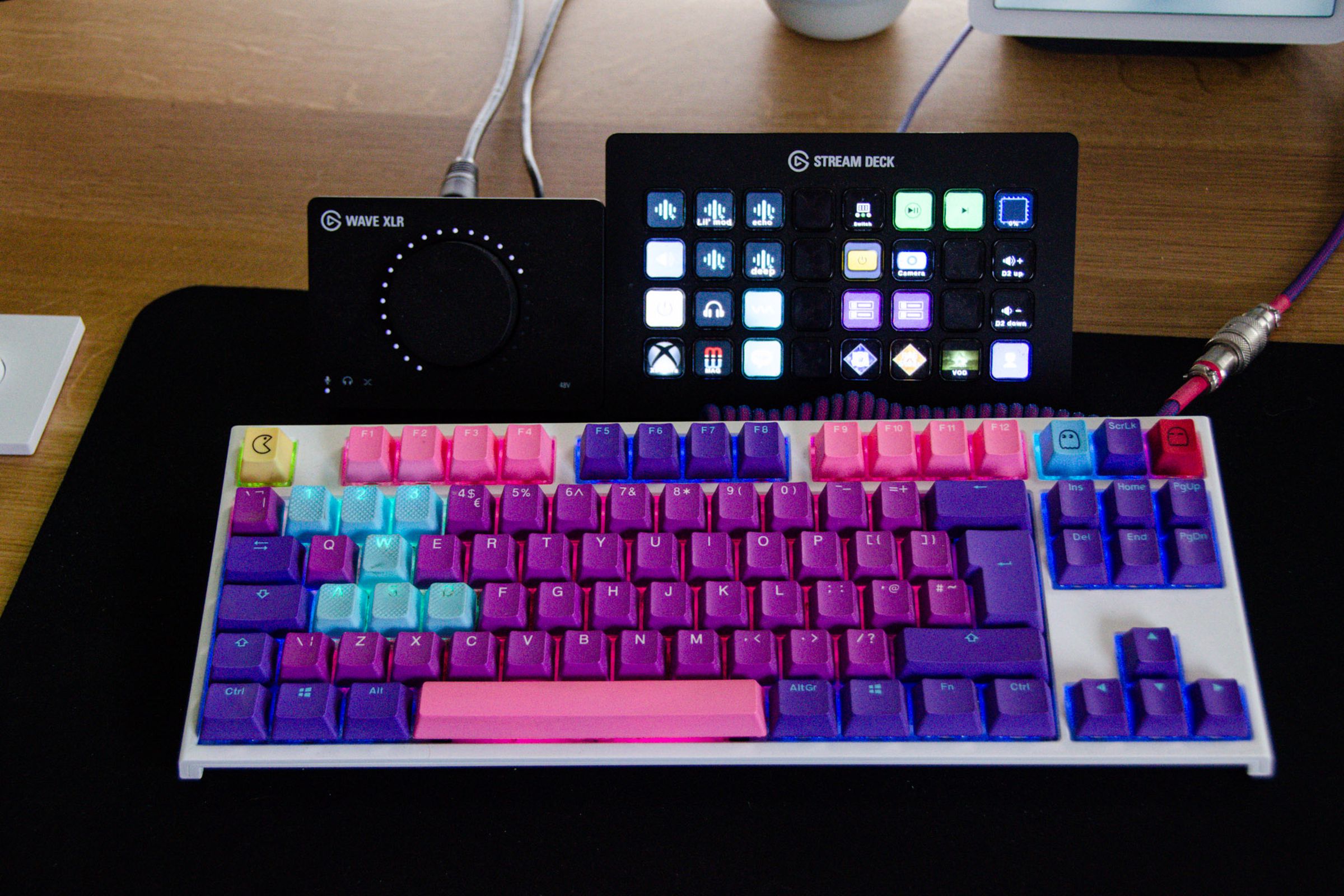 A colorful gaming keyboard, behind it is a volume switch and a Stream Deck button console.