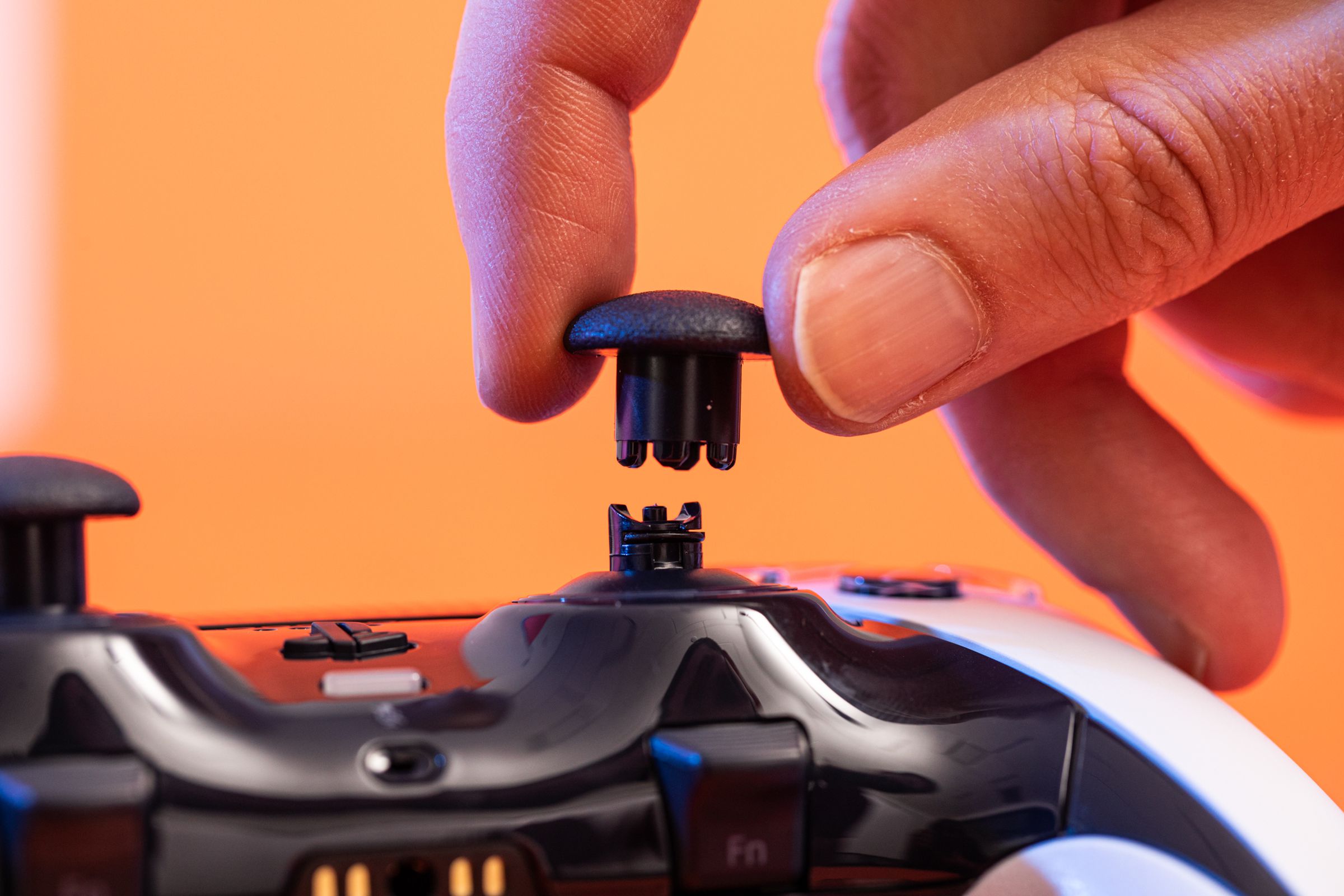 A side shot showing an analog stick head being installed on the Sony DualSense Edge controller