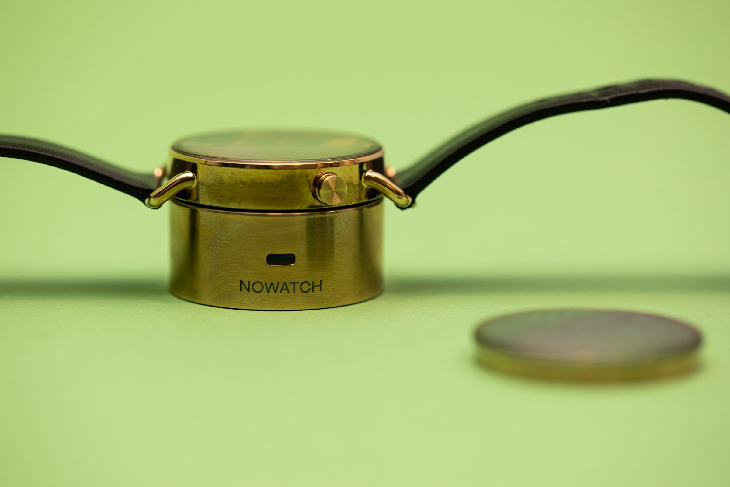 Nowatch device on top of the charging dock with the alternate disc in the foreground.